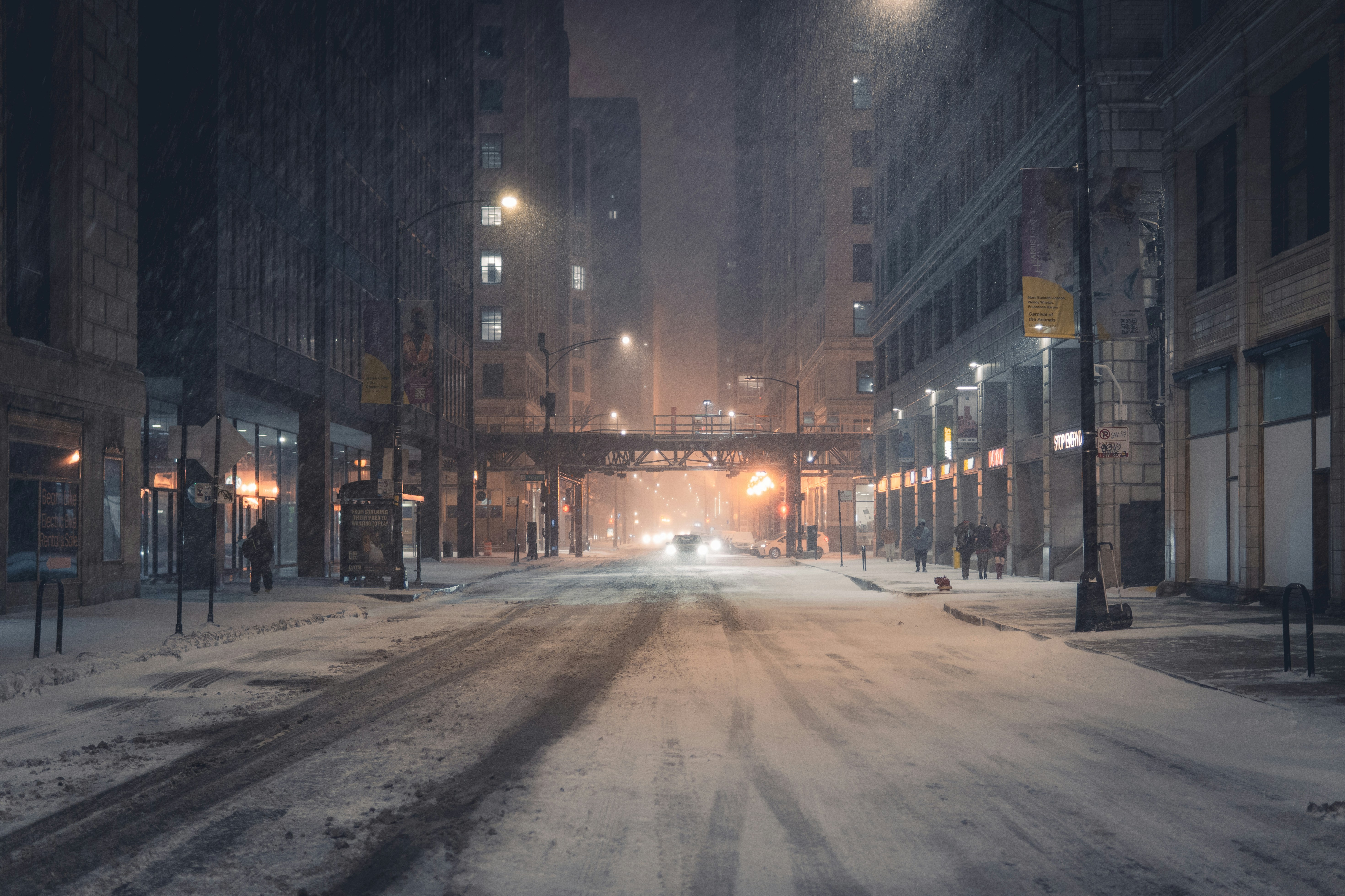 Snow falling on a city street at night
