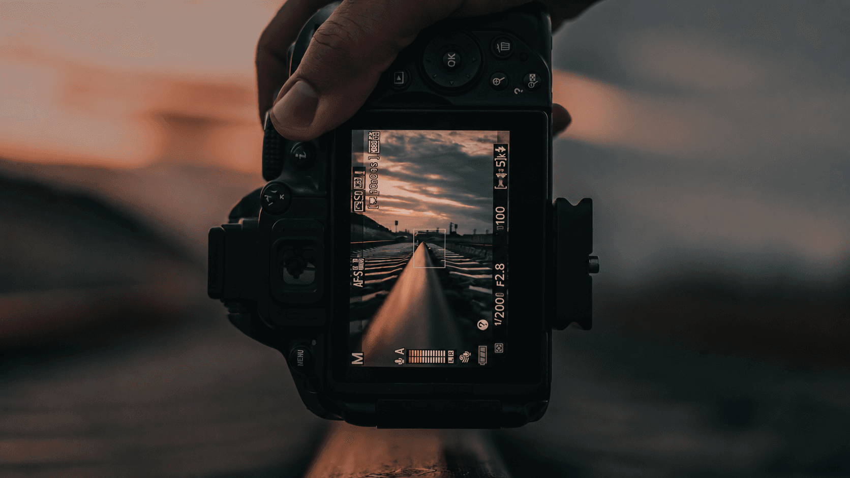 A photographer holding a camera at dusk