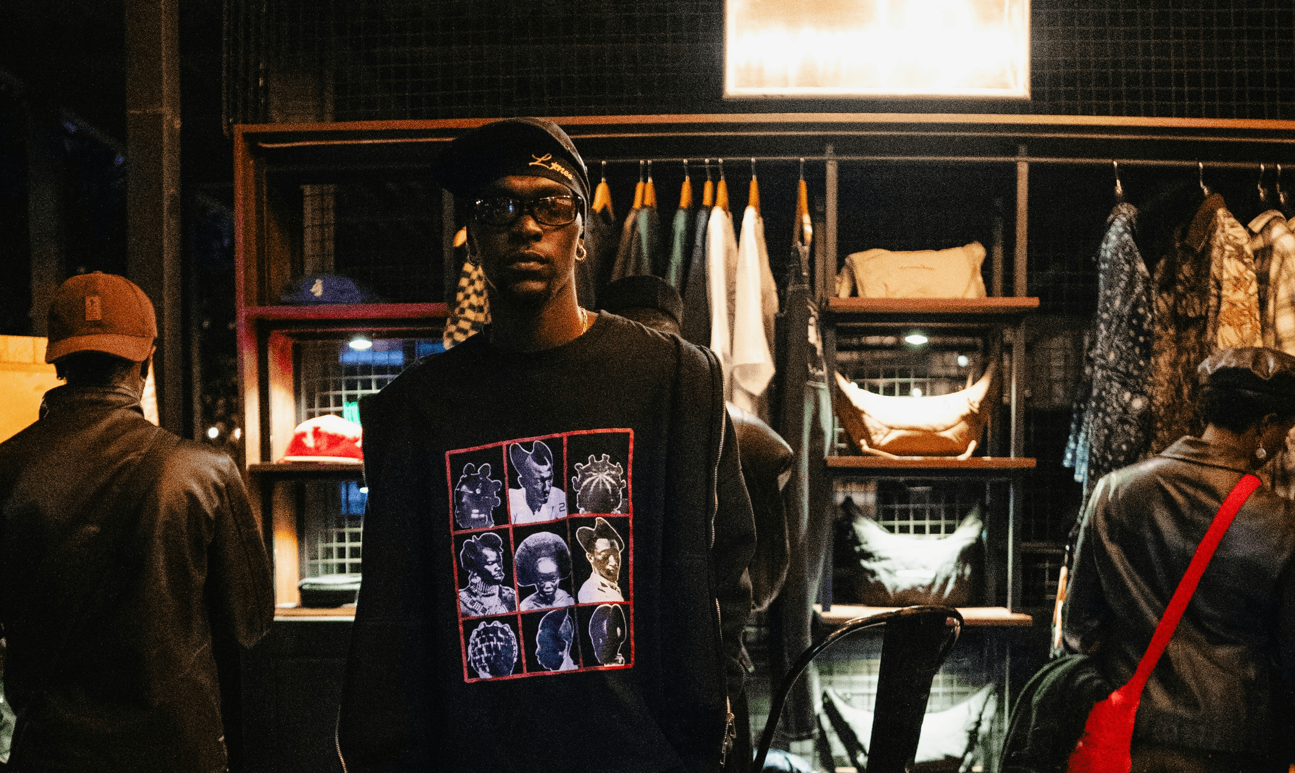 Man in black sweatshirt with collage stands in store