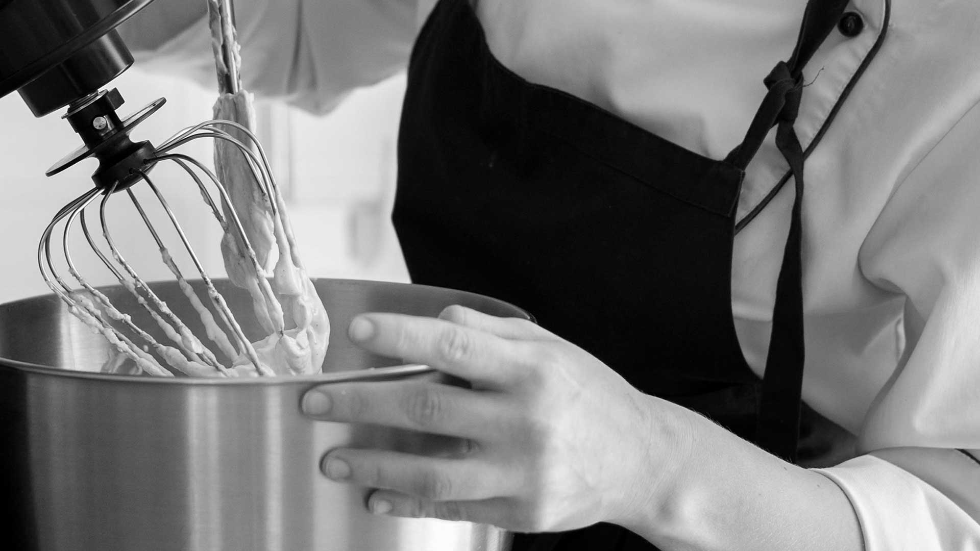 Кухар користується електромеханічним міксером для приготування тіста