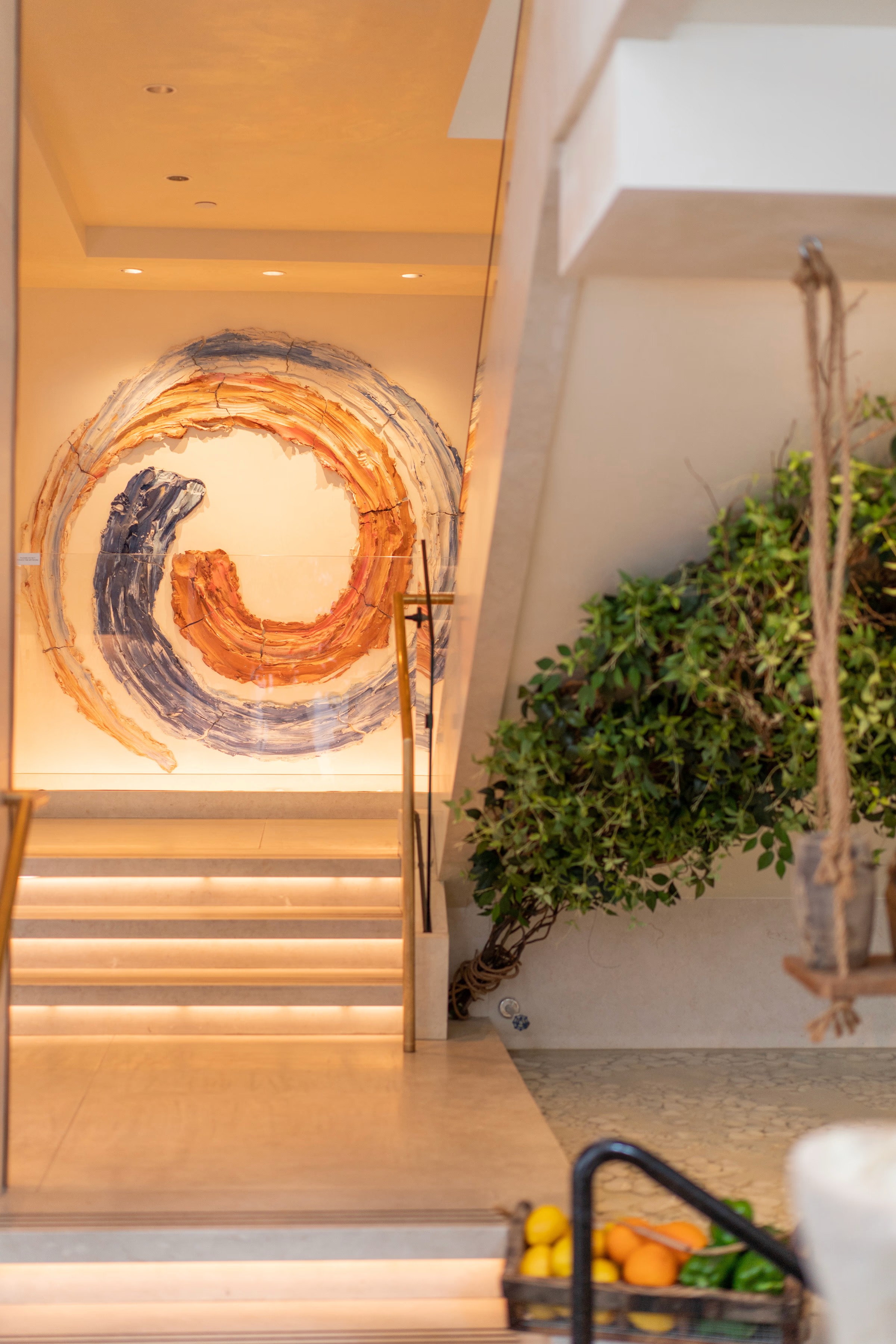 A close-up view of a decorative spiral design on a wall, accompanied by greenery and modern furnishings.