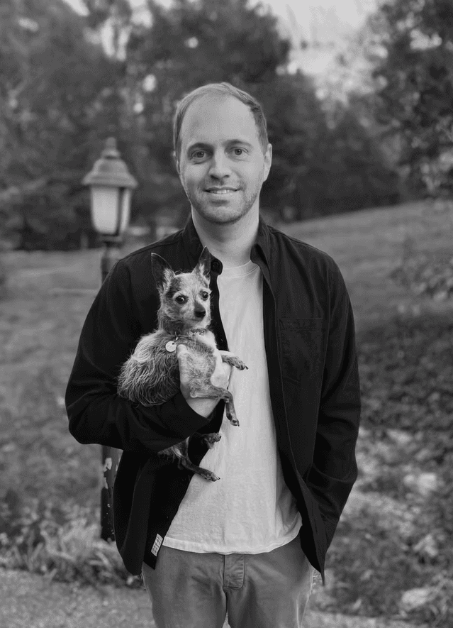 black and white photo of me holding my 5 pound chihuahua mix with a large yard behind me