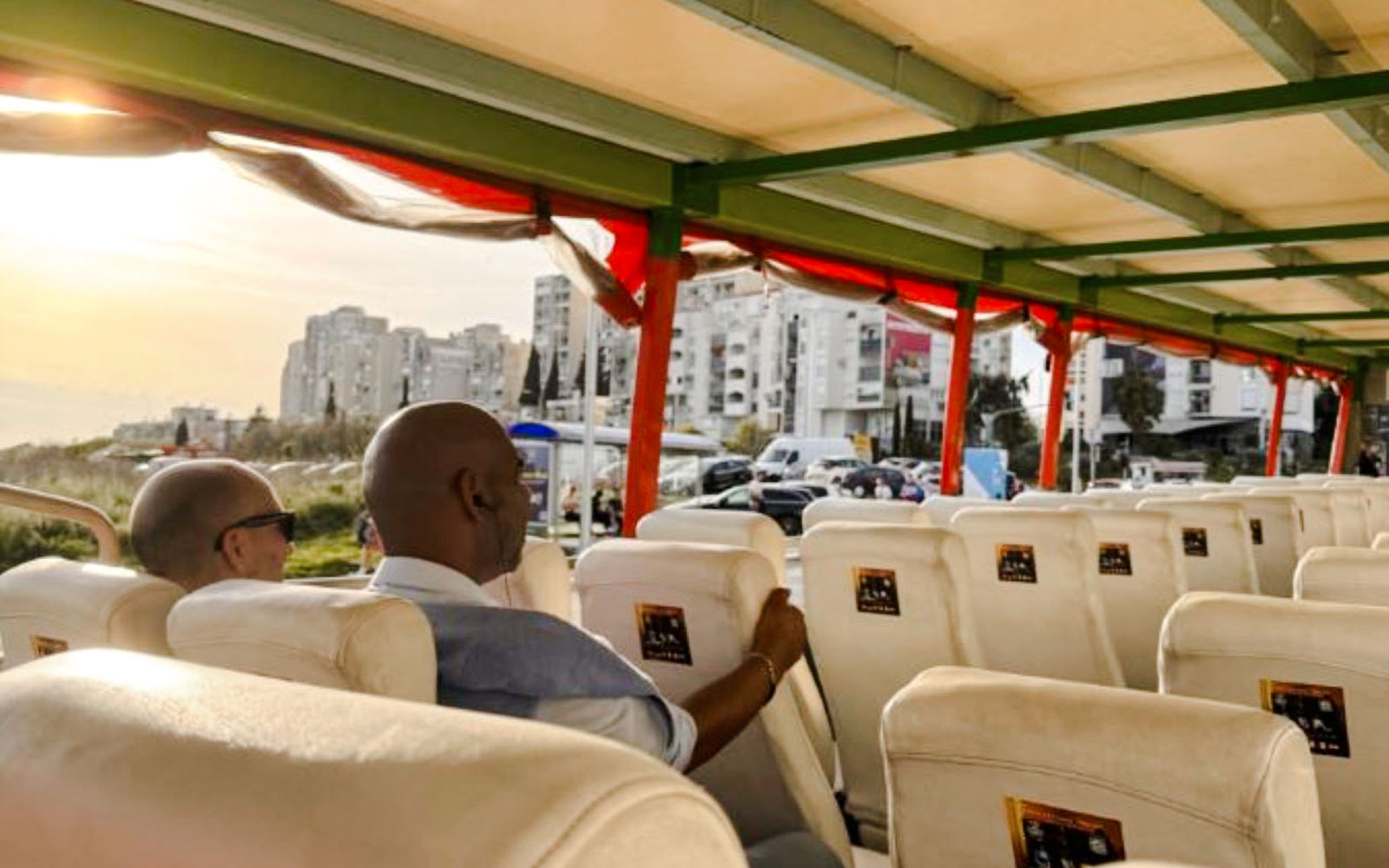 Turisti su un autobus diretto alla Fortezza di Klis al tramonto, con lo skyline della città sullo sfondo.