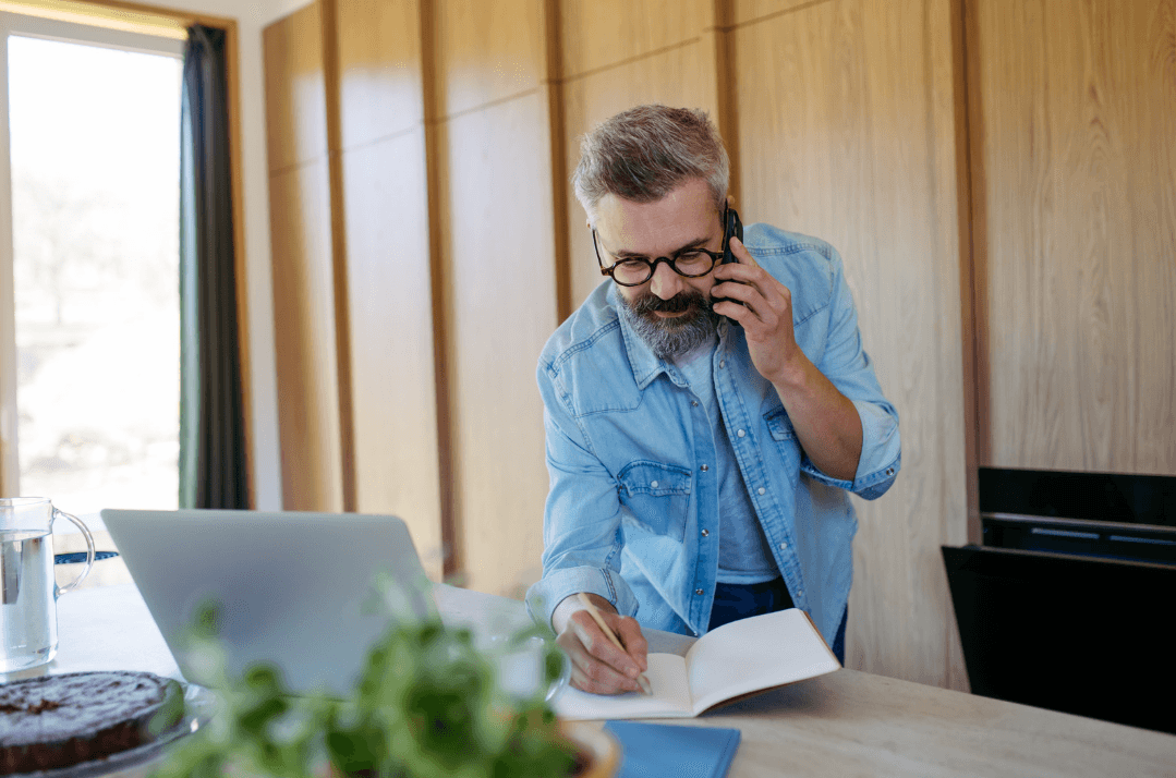 Facility manager manually tracking maintenance updates through phone calls and handwritten notes, rather than using facilities management software.