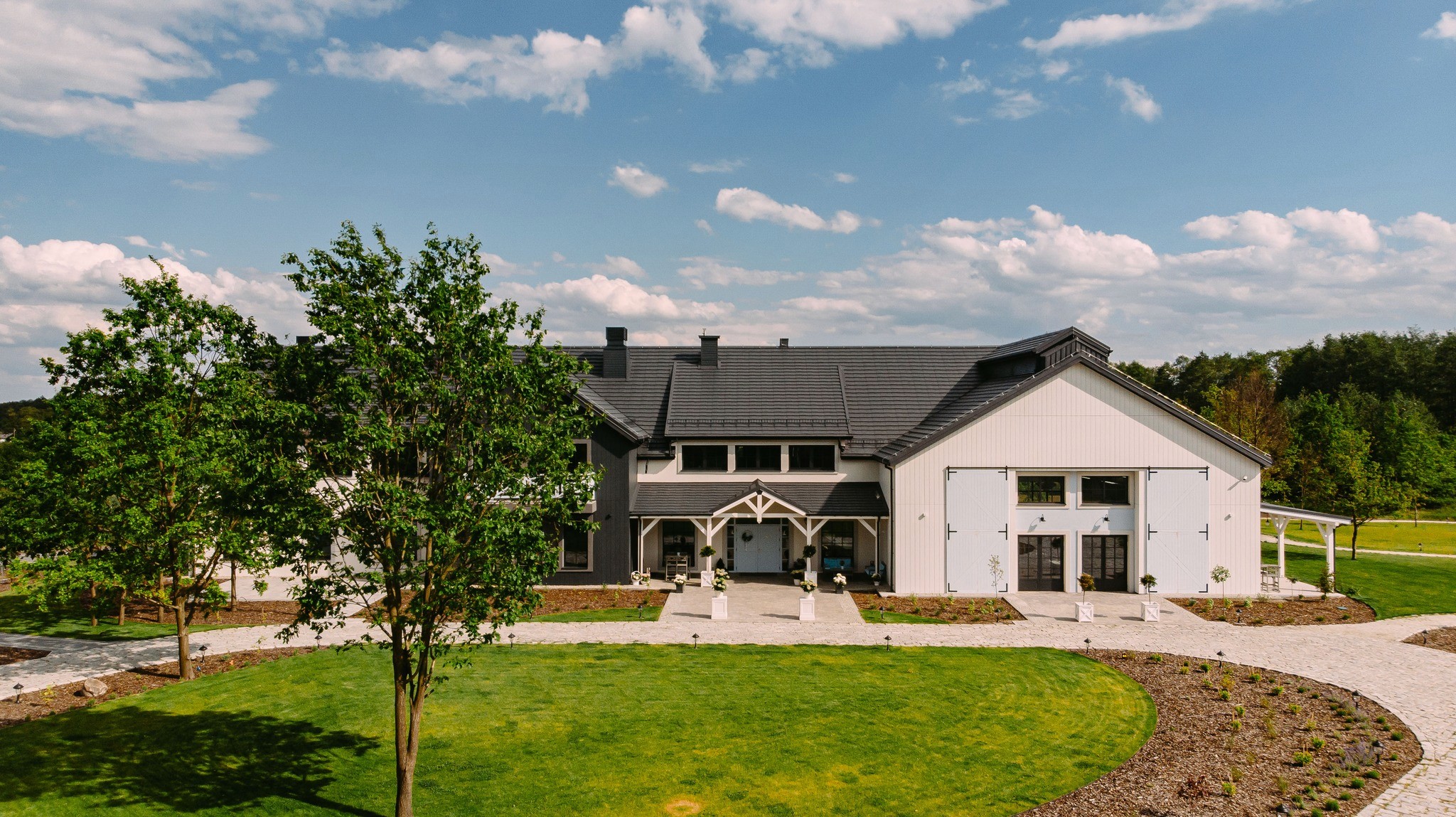 Panoramic view of a historic stone manor house within a vast green landscape at sunset
