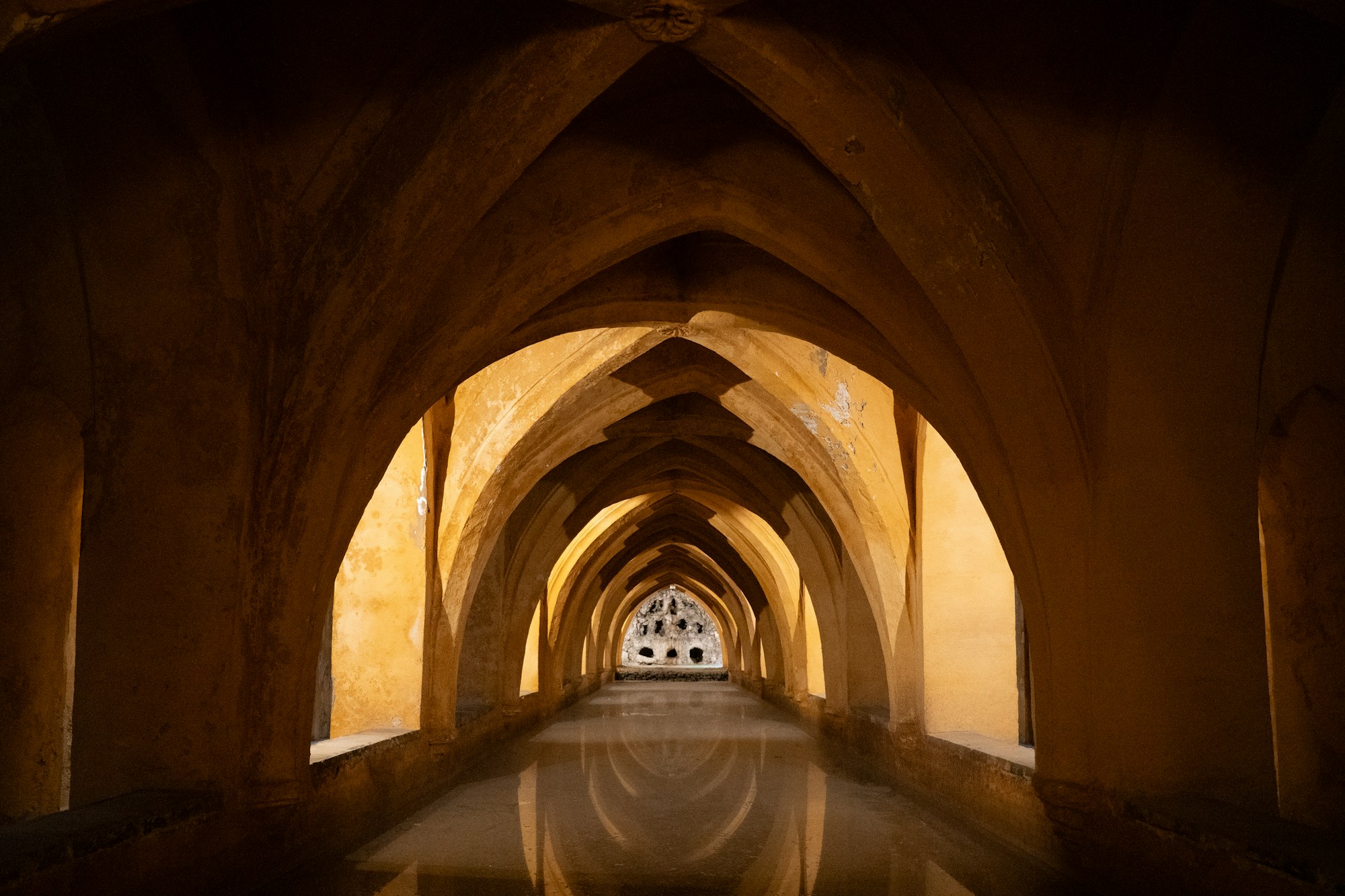 Golden light along a corridor of vaulted arches