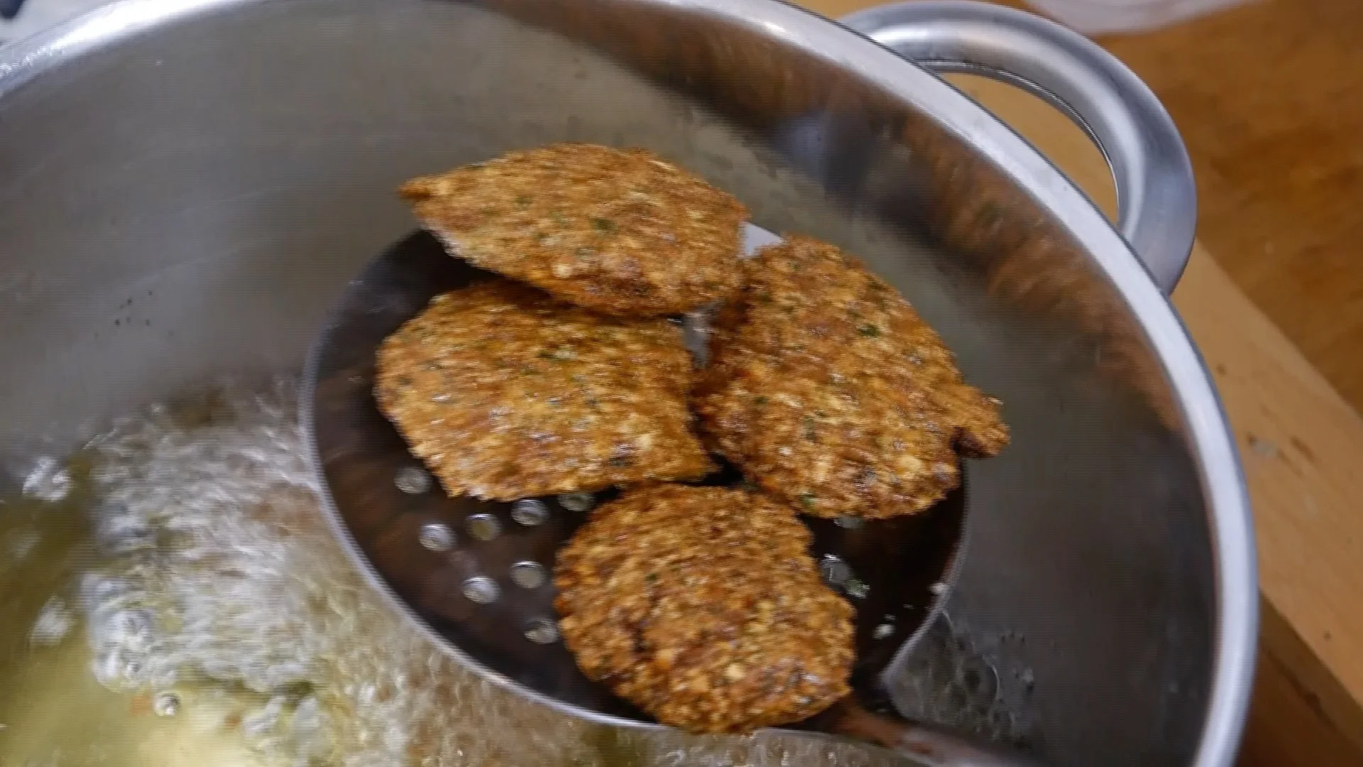 Falafel over frying pan with hot oil