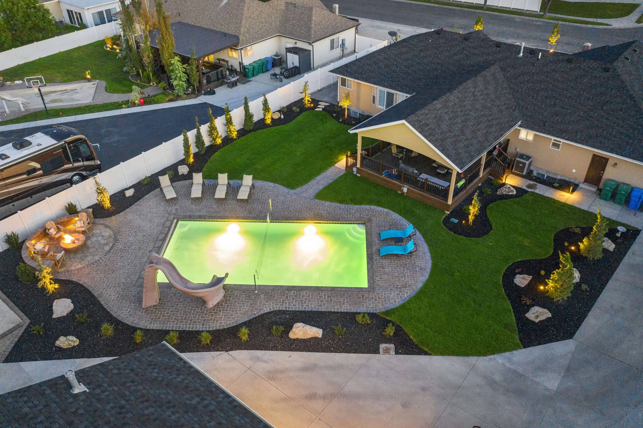 Riverton Residence resort-style in-ground pool with slide and paver deck surround