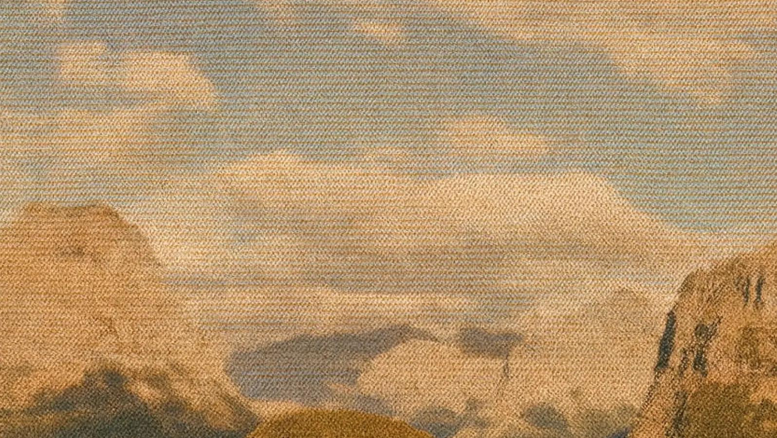 Distant rocky peaks beneath layered clouds in a warm-toned landscape.