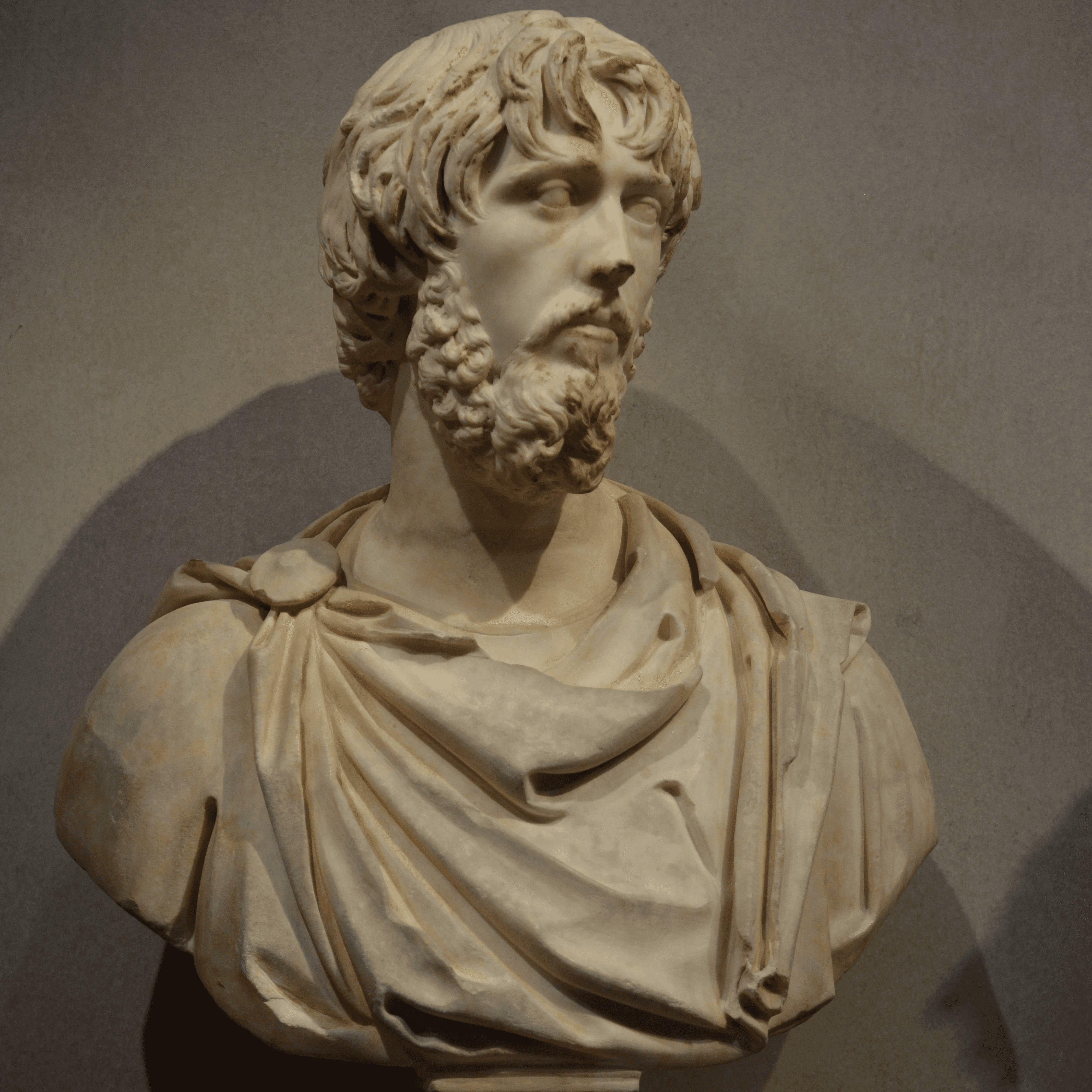 A young person with long, wavy hair sits in front of a plain background, looking directly at the camera.