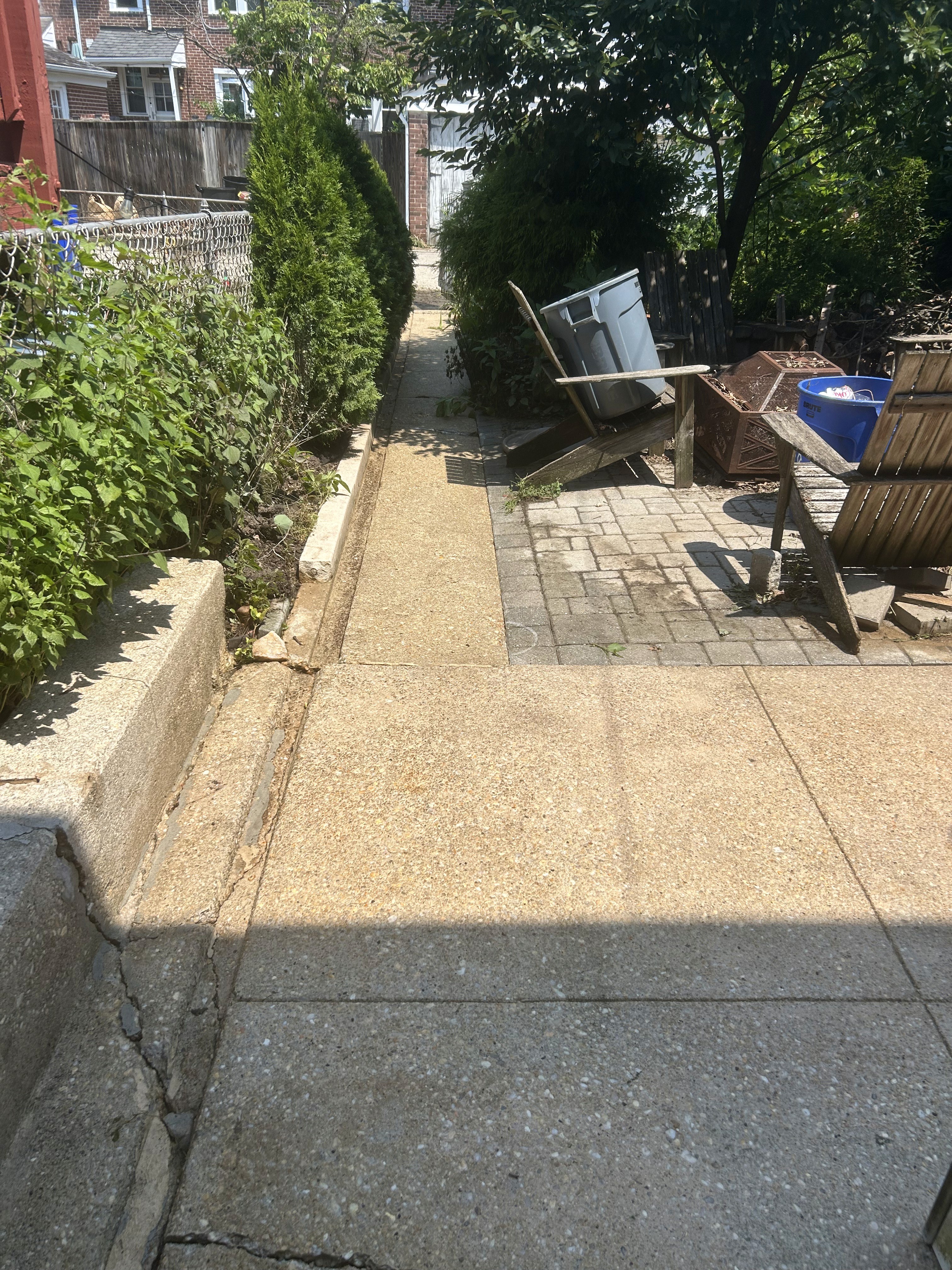 Clean rear concrete walkway and patio area after pressure washing in Rodgers Forge.