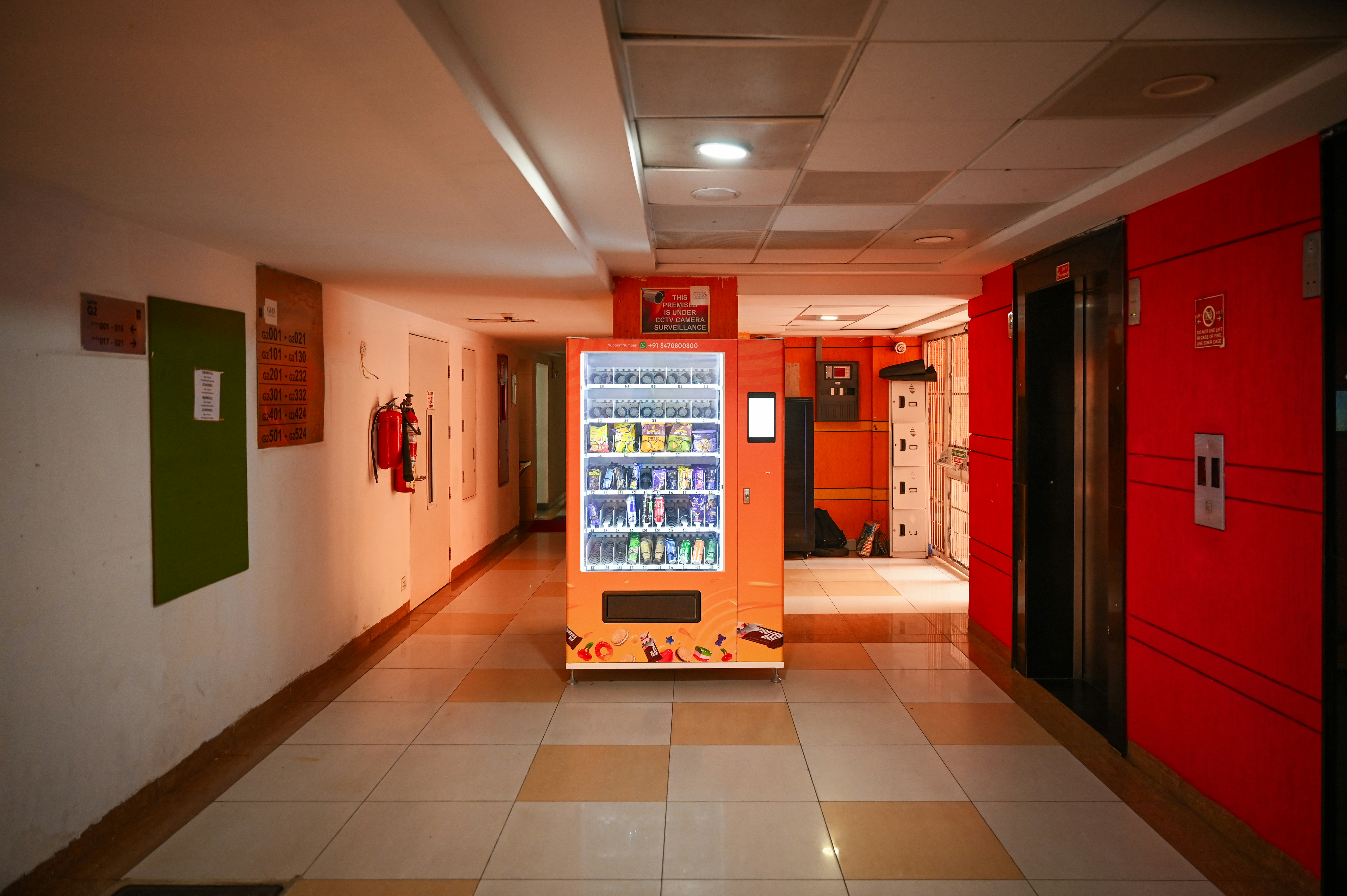 Hallway with a vending machine and elevator.