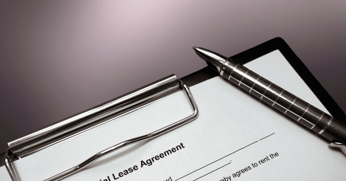 A residential lease agreement on a clipboard with a pen