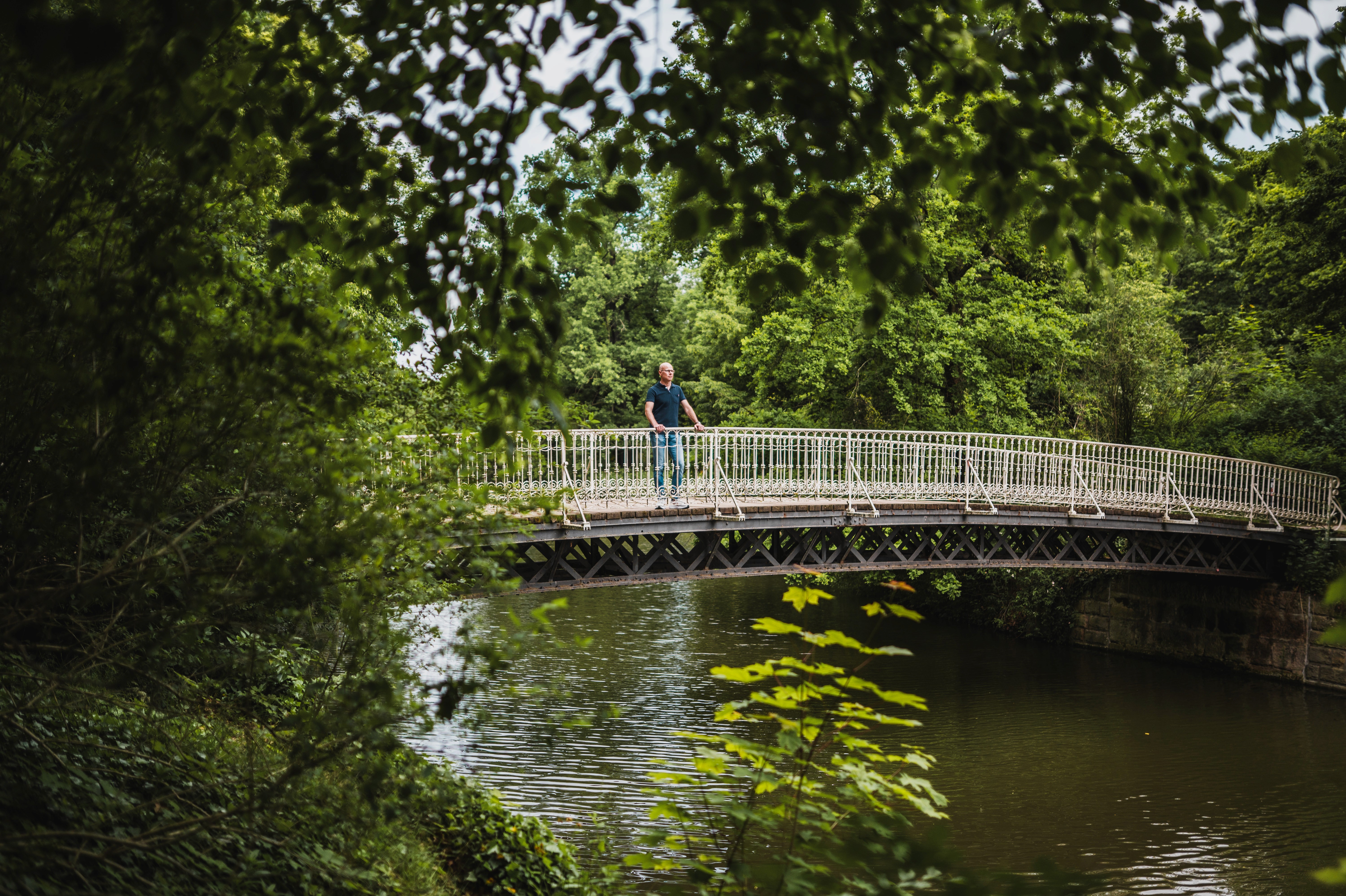 Sven Eichner steht auf einer Brücke über einem See