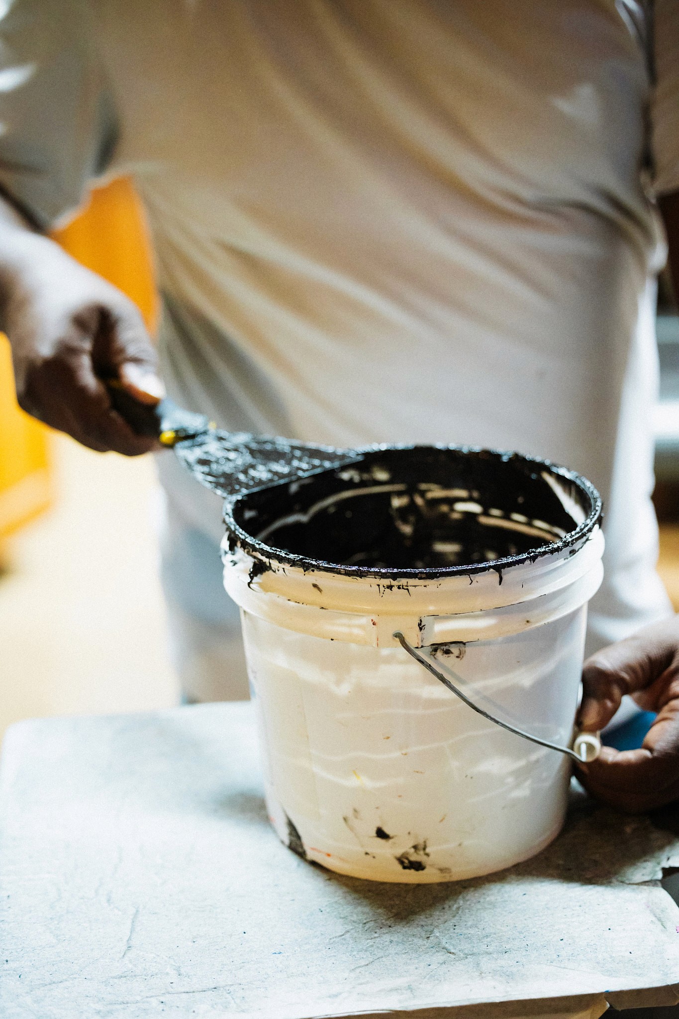 small business owner getting paint from a bucket