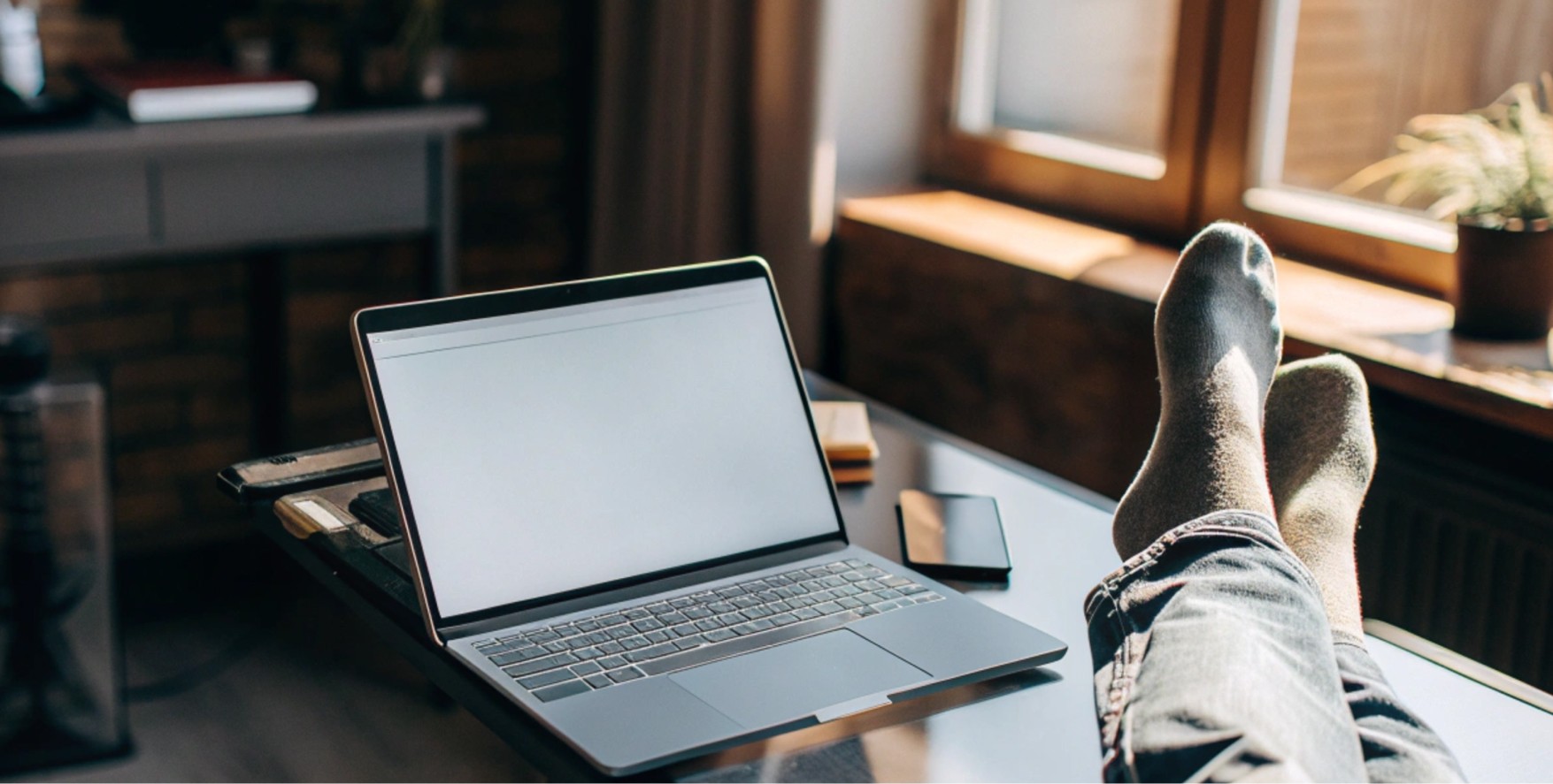 Laptop on desk near window, relaxed home workspace