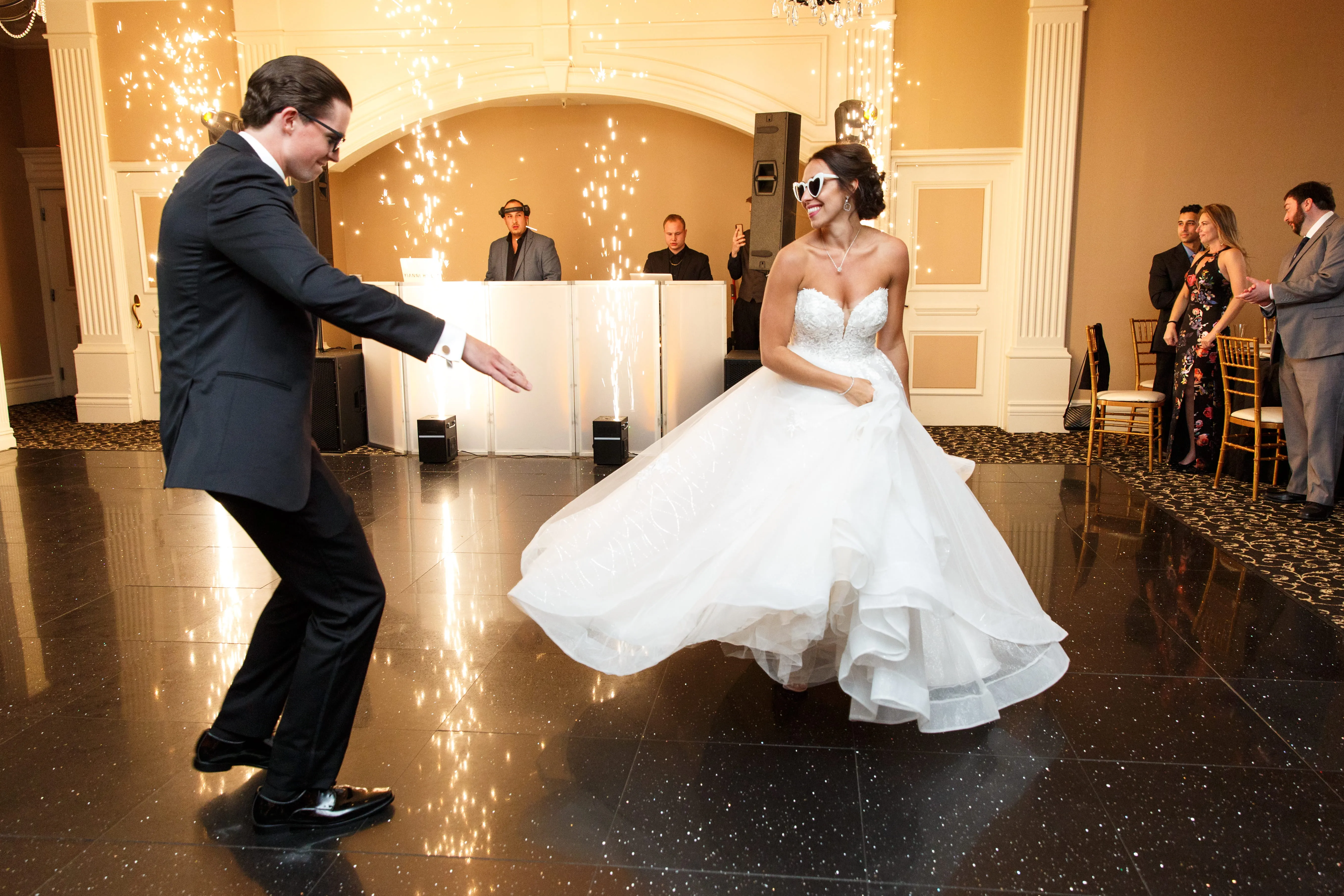 Bride and groom dancing at wedding reception with DJ creating high energy atmosphere