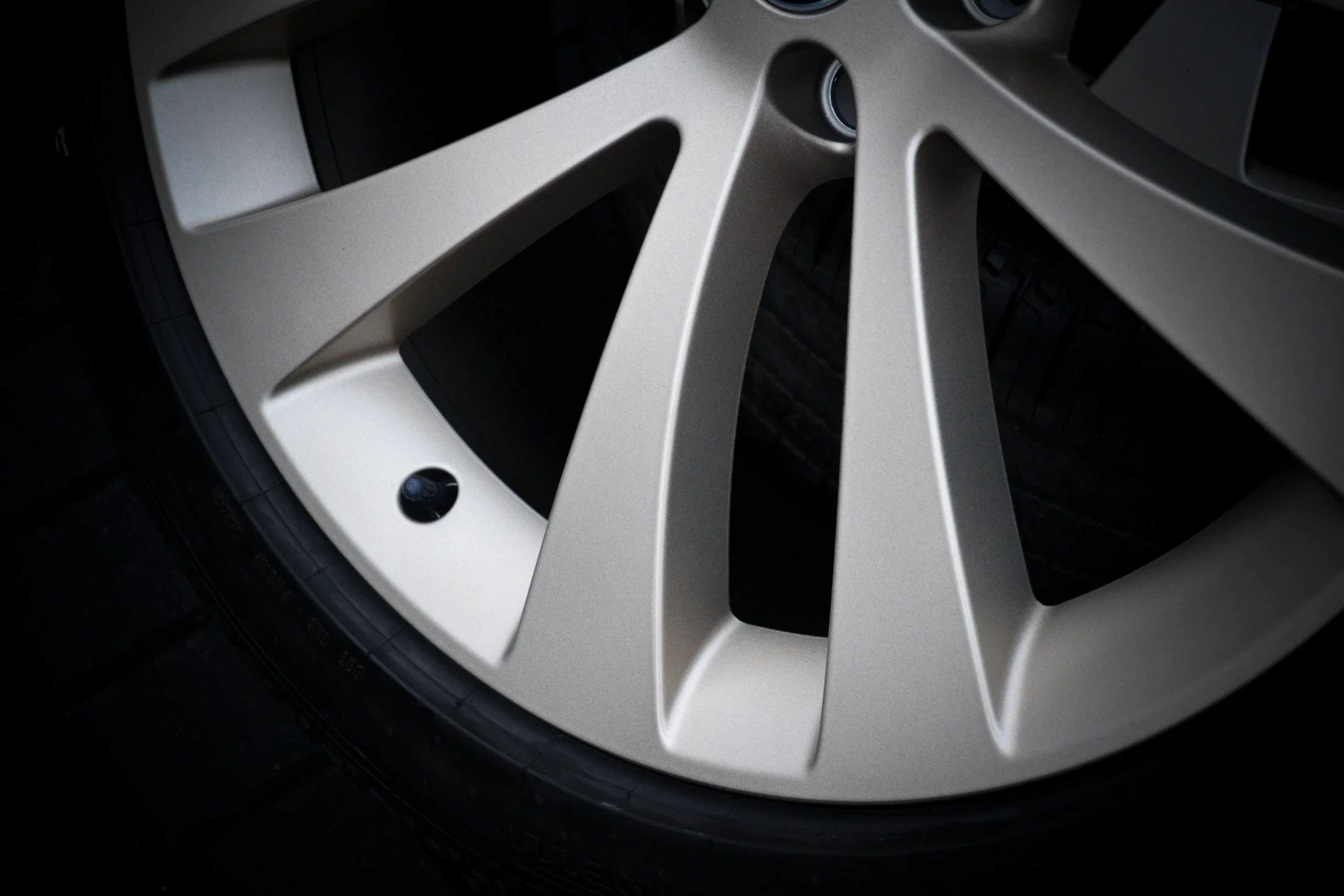 Detail der breiten, hellen Speichen und des Felgenrands einer Land-Rover-Felge bei AT Plus.