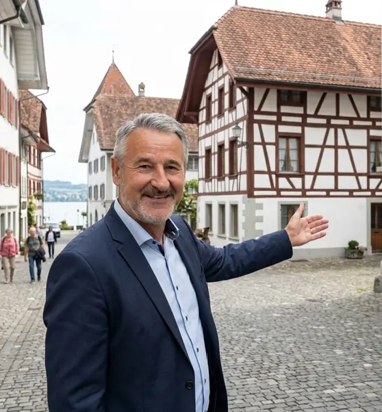 Professioneller Immobilienpartner zeigt auf ein historisches Gebäude in der Region Sempach