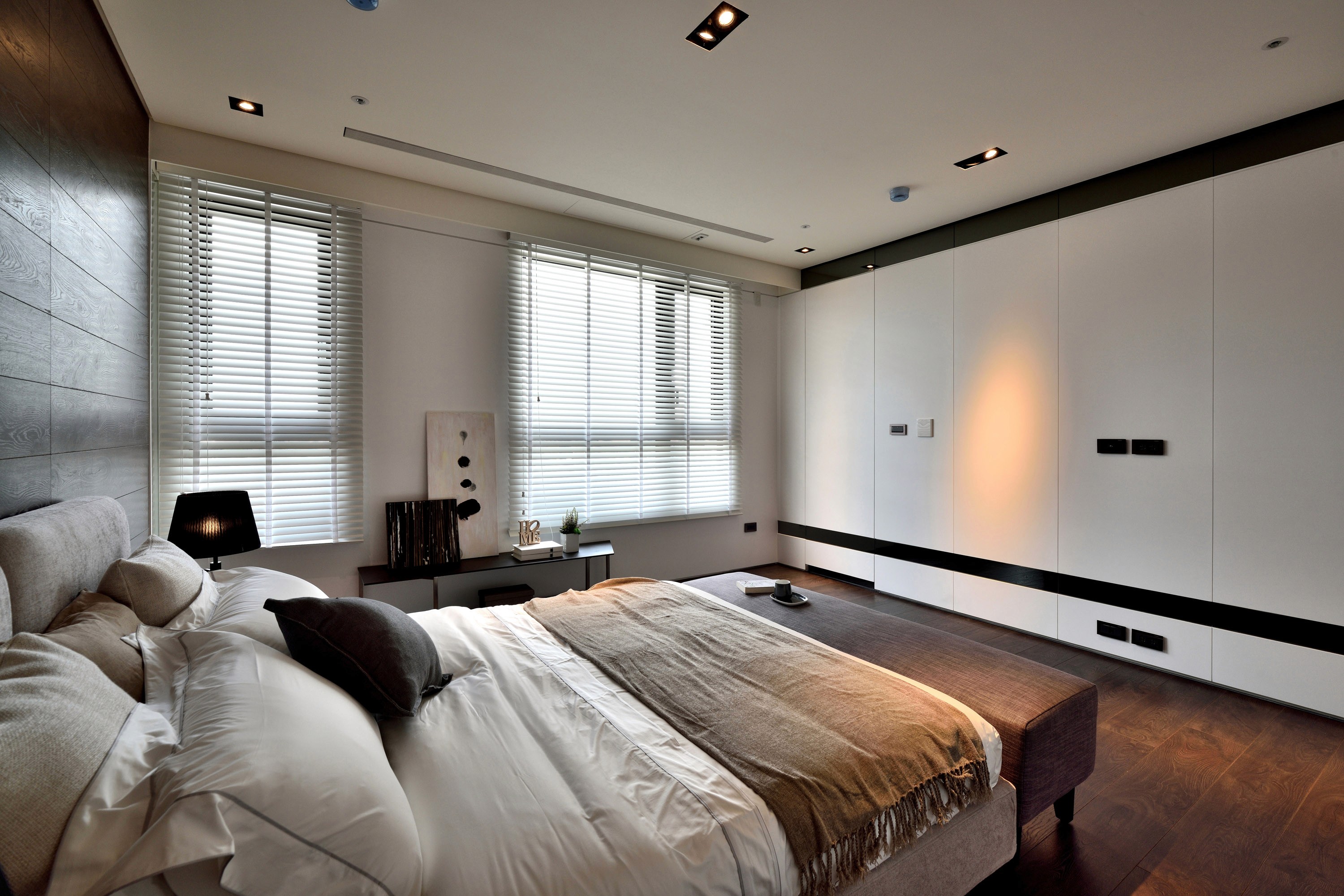 Interior bedroom with wood wall and white wardrobes, daytime
