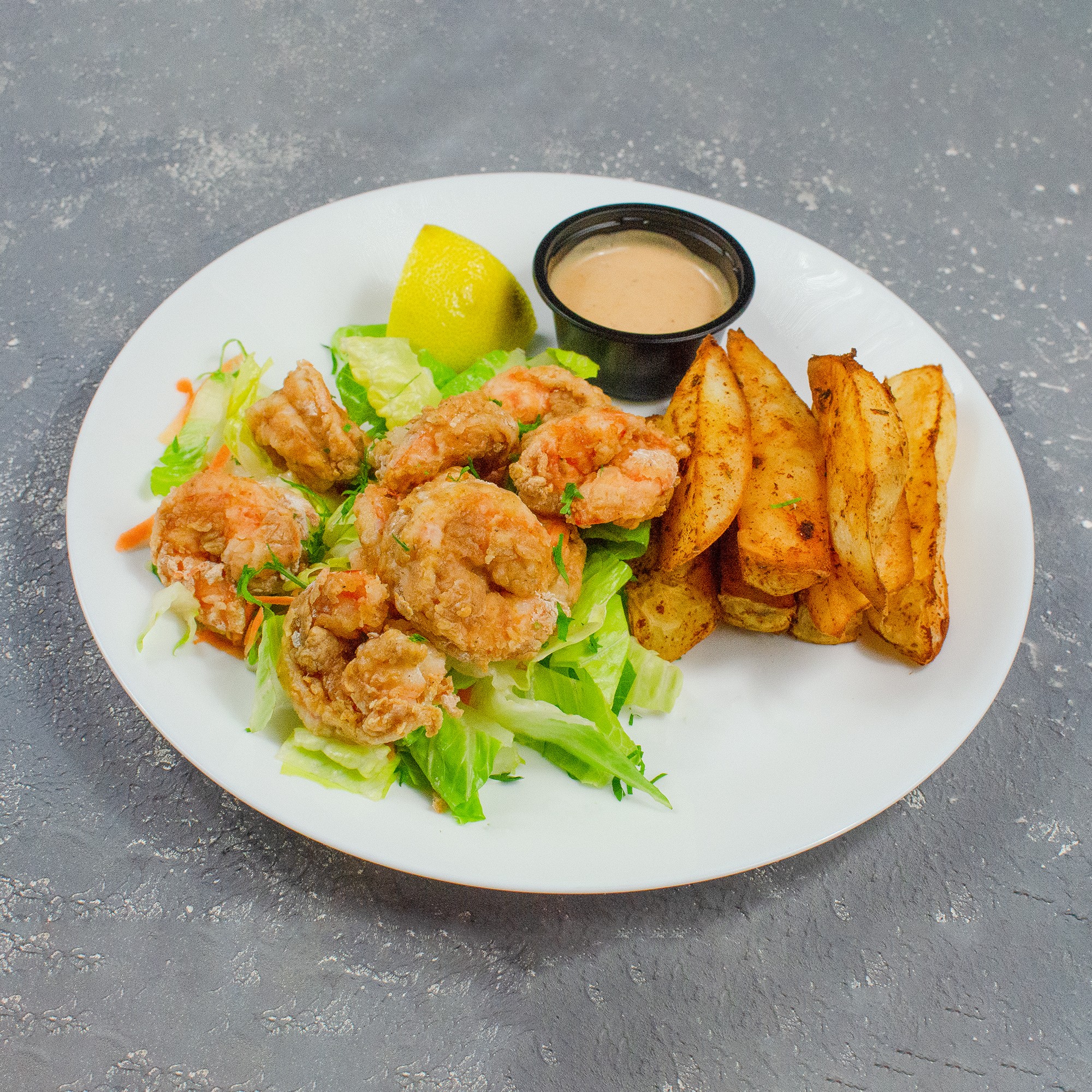 A rustic table set with various traditional pastries and a small bottle, surrounded by green foliage.