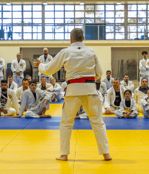 Instructor addressing a large group of students during a belt ceremony