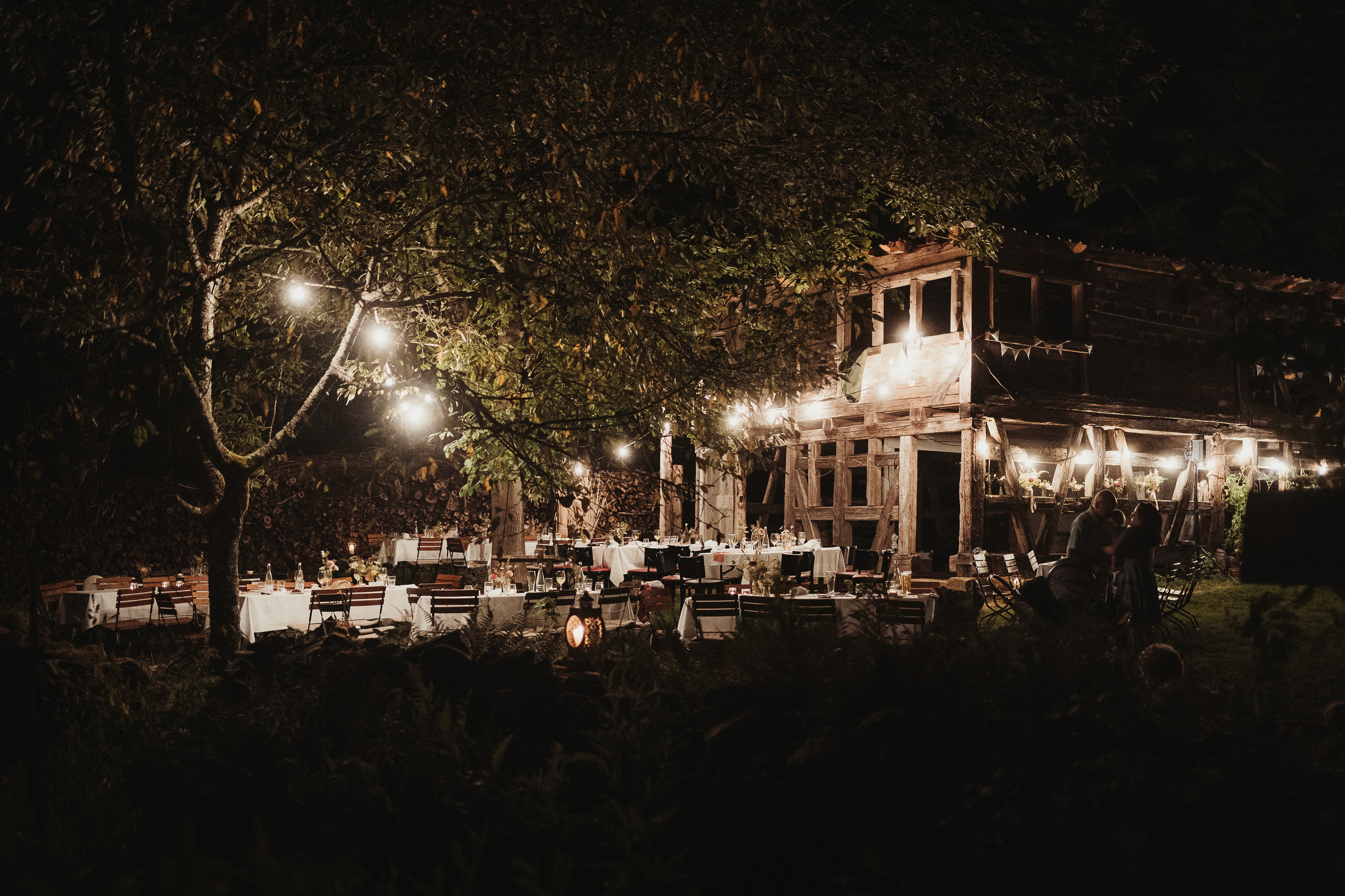 Fachwerkhaus und Freiflächen beleuchtet bei Nacht.