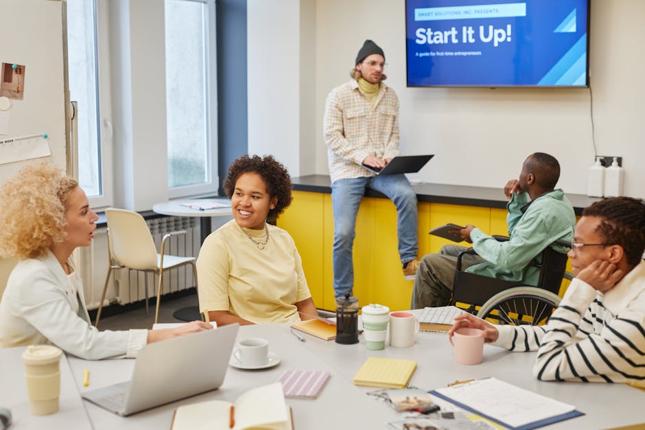 A diverse team of designers and developers collaborating around a table, looking at website mockups on screens - retail website designer