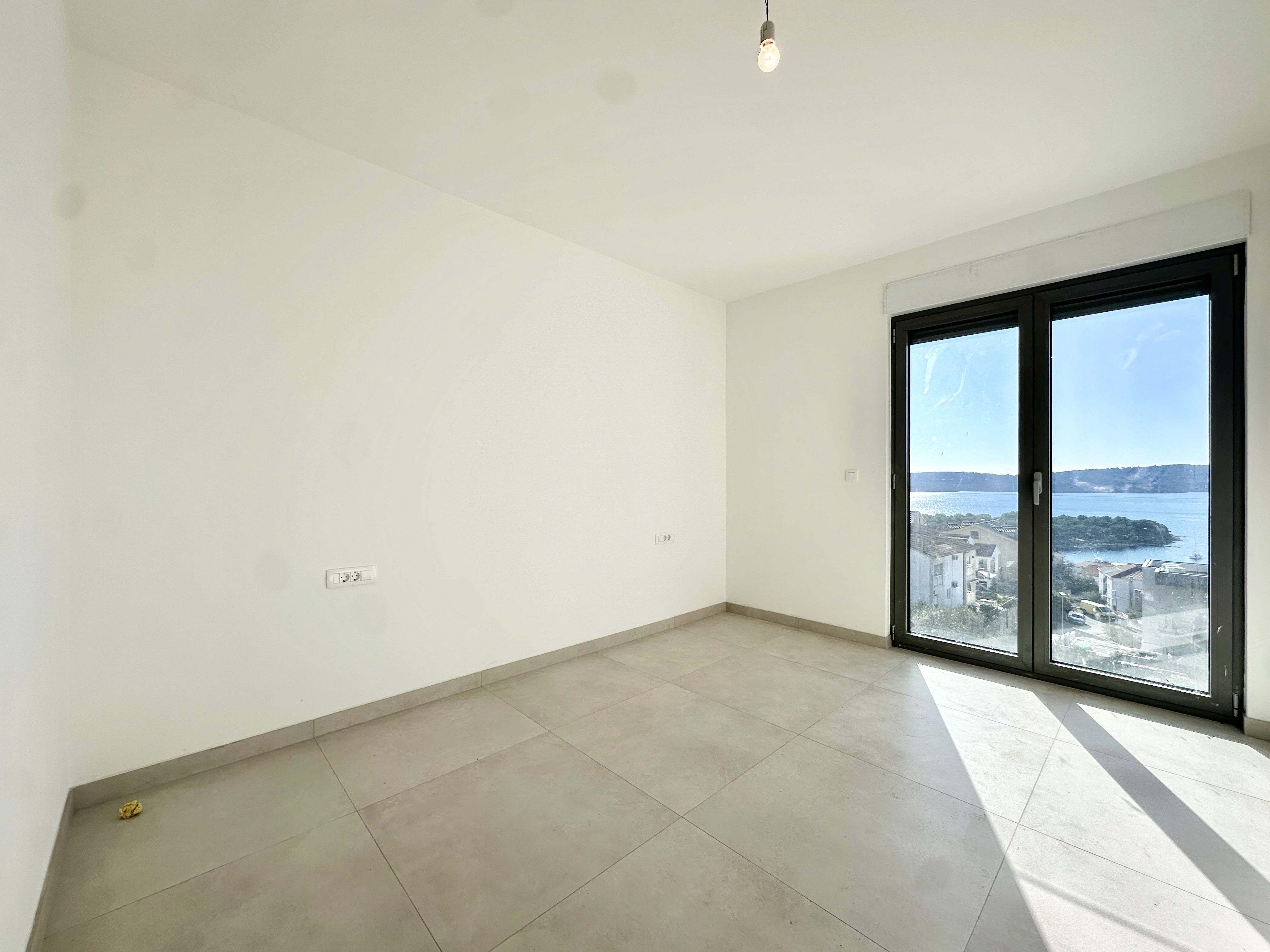 Black sports car in front of a modern, futuristic curved building.