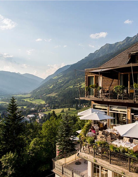 Außenfassade & Terrasse des Alpine Spa Hotel Haus Hirt mit Blick auf die umliegende Landschaft.