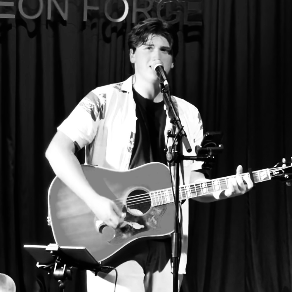Man rapping into microphone on stage