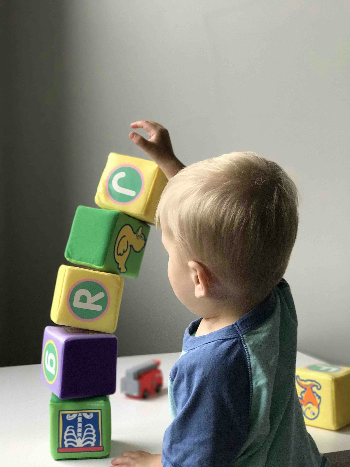 Toddler playing with colourful building blocks