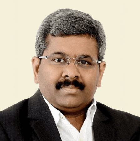 Man with arms crossed in modern office workspace.