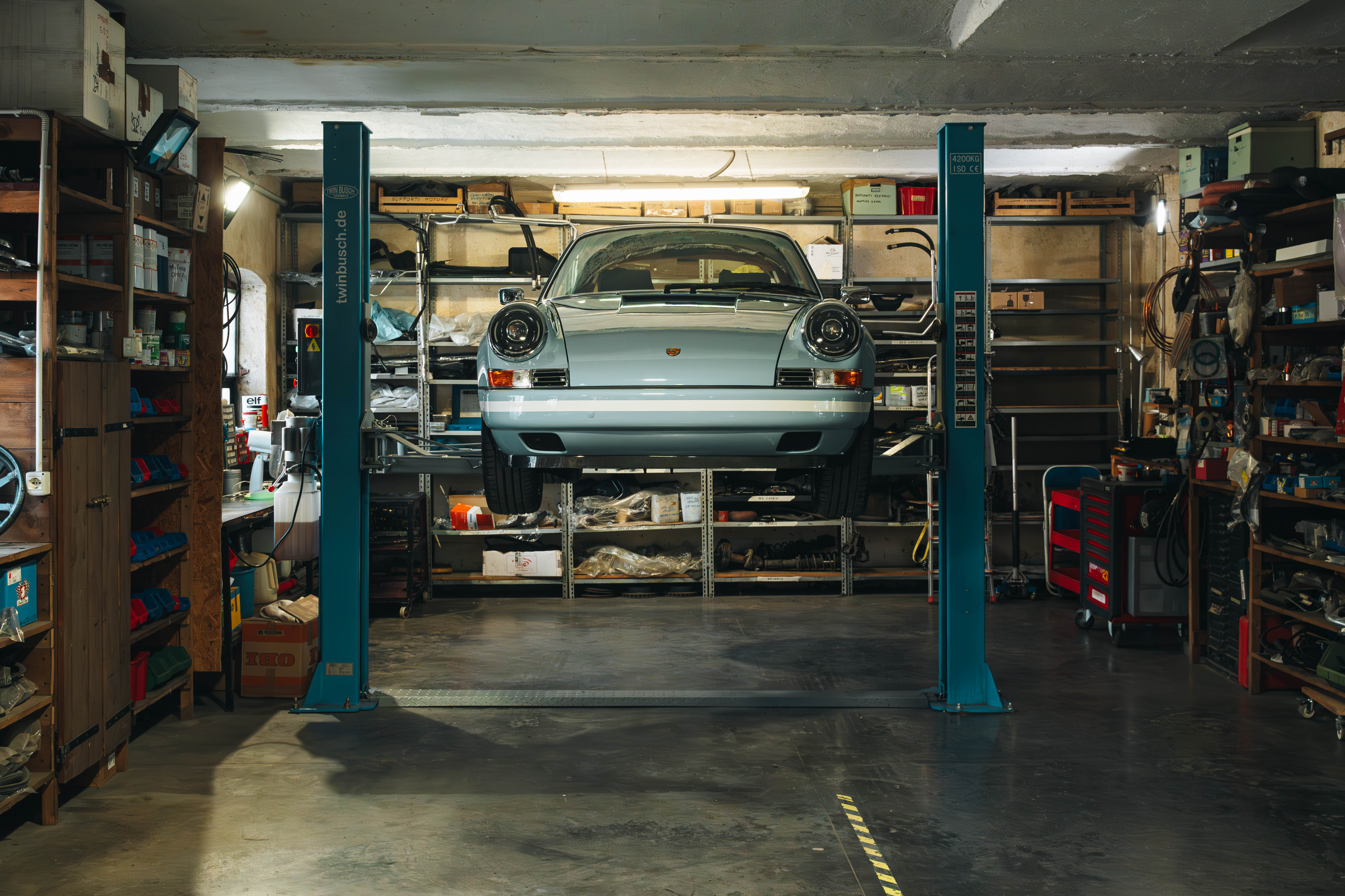 Porscje Azzurra su ponte in officina vista frontalmente