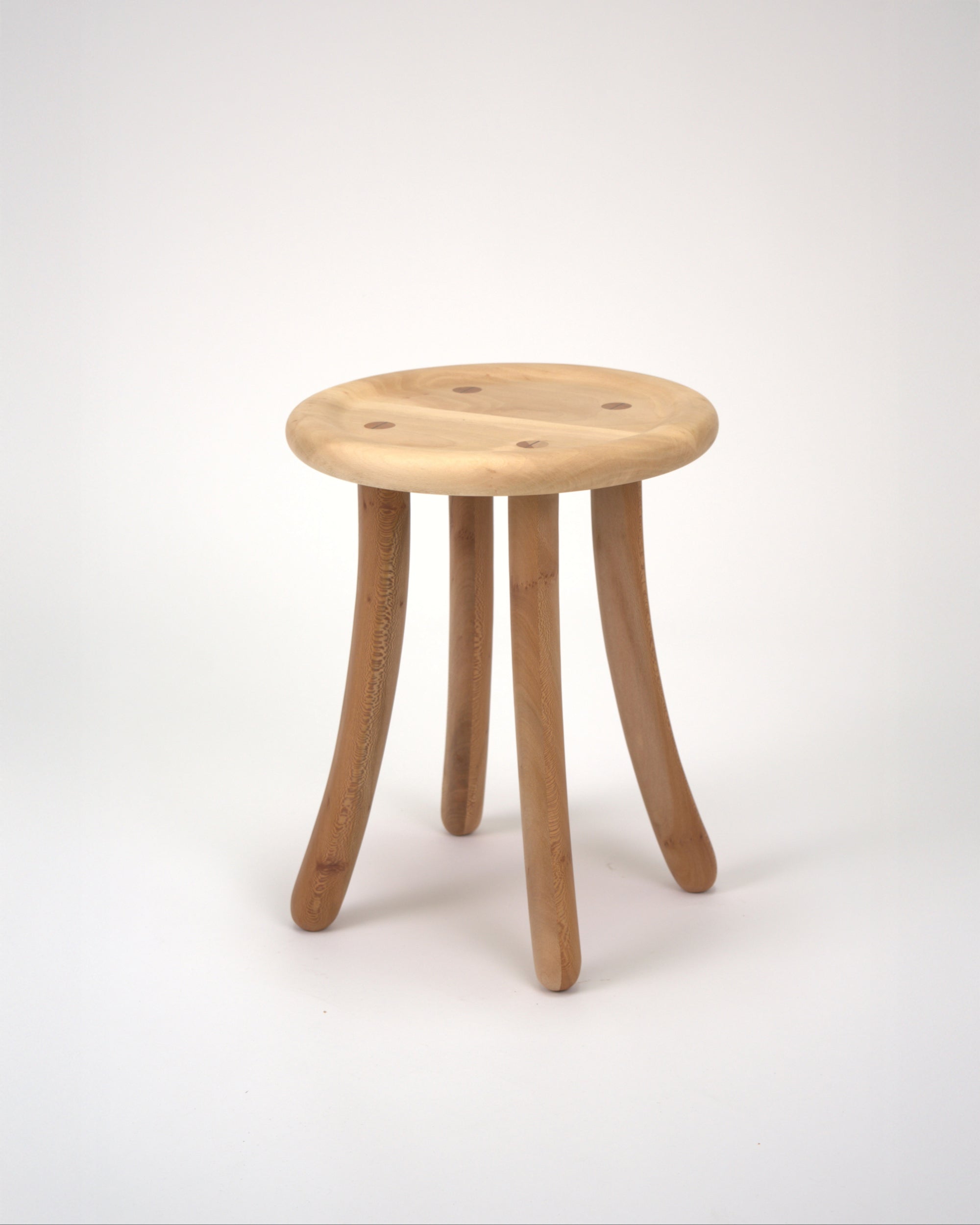 Wooden Luneta stool with four curved legs on a white background
