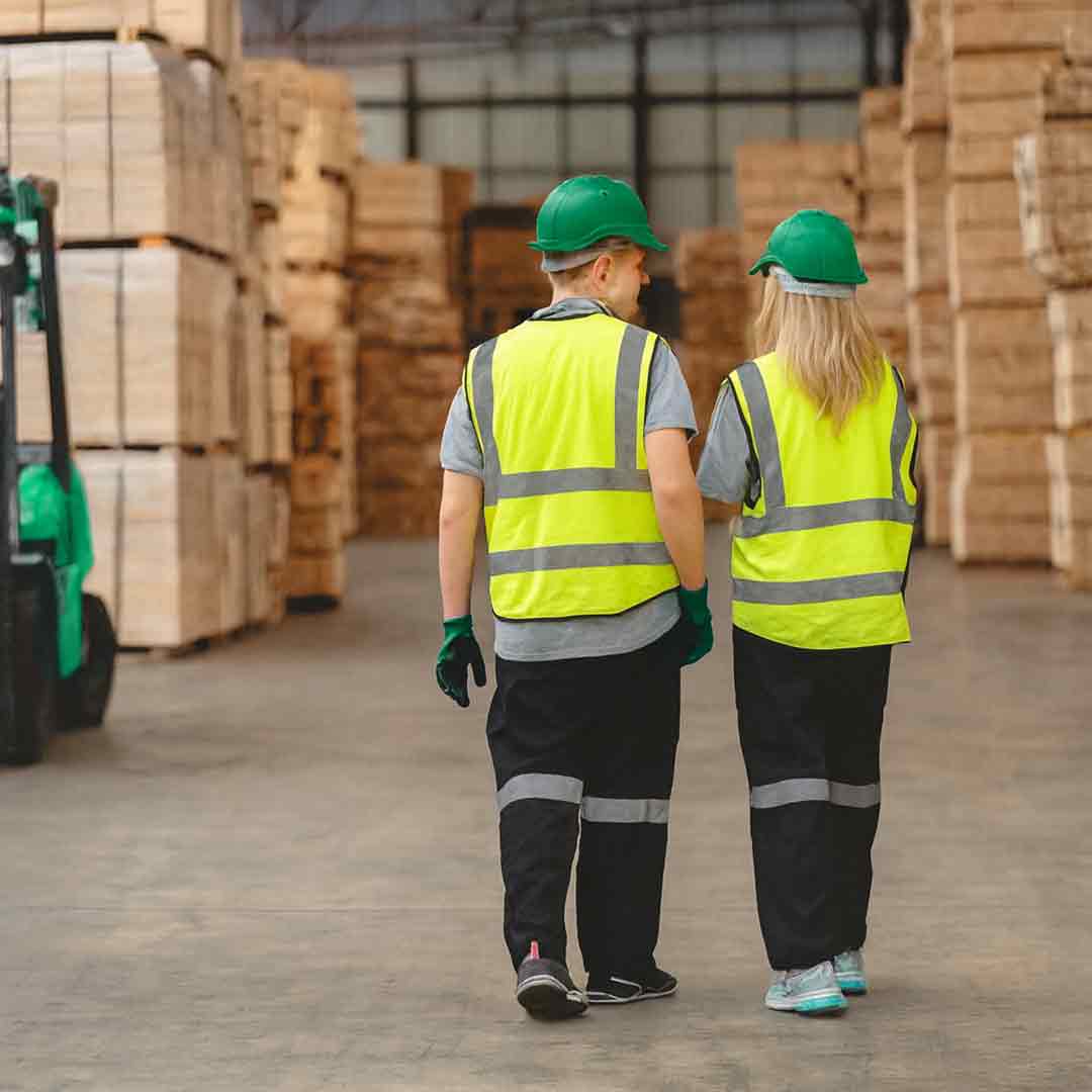 Робітники у захисних касках і жилетах працюють у великому складі