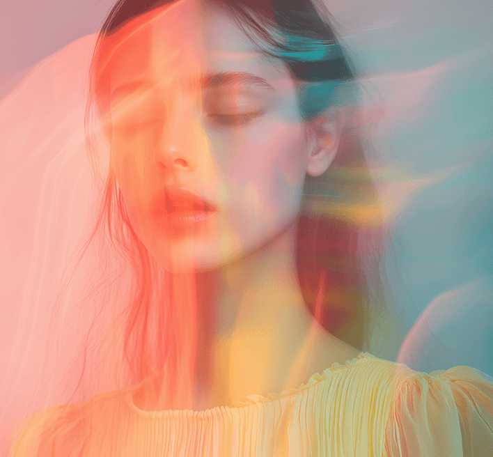 A woman with her eyes closed is illuminated by a colorful light, evoking a sense of peace and introspection.