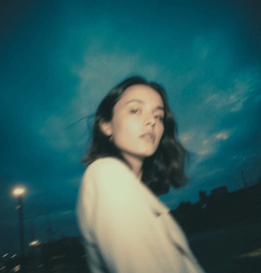 City street at night with neon lights and people.