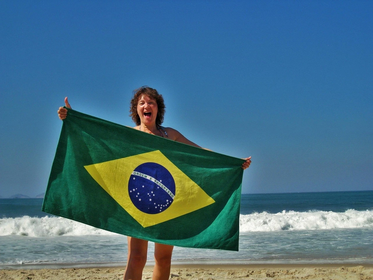Turista disfrutando de las playas de Brasil tras activar su modo seguro con Pix y Takenos.