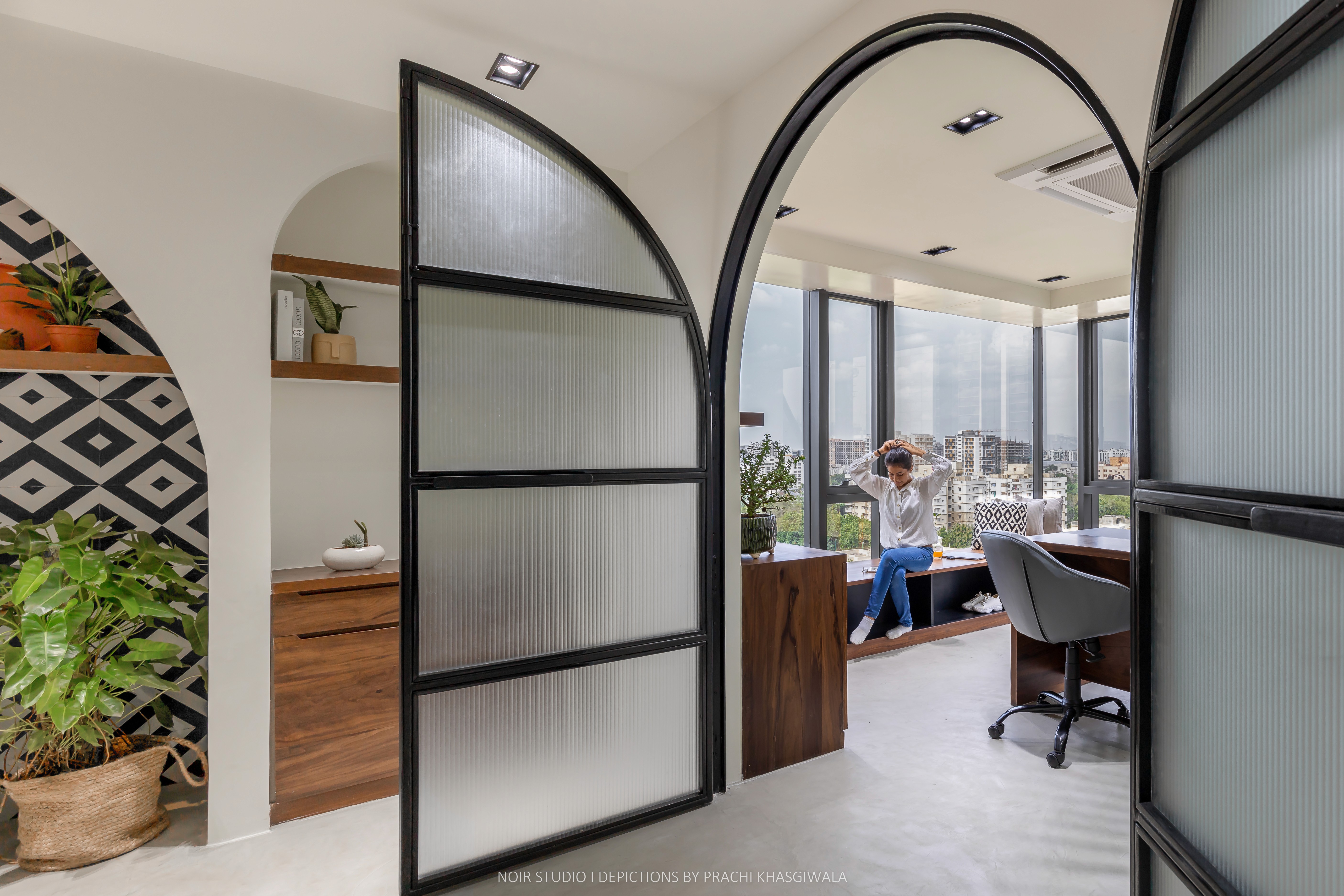 Black and white image of people working at a table with laptops, showing hands gesturing during discussion of digital content displayed on screens, with fabrica® logo in the corner.