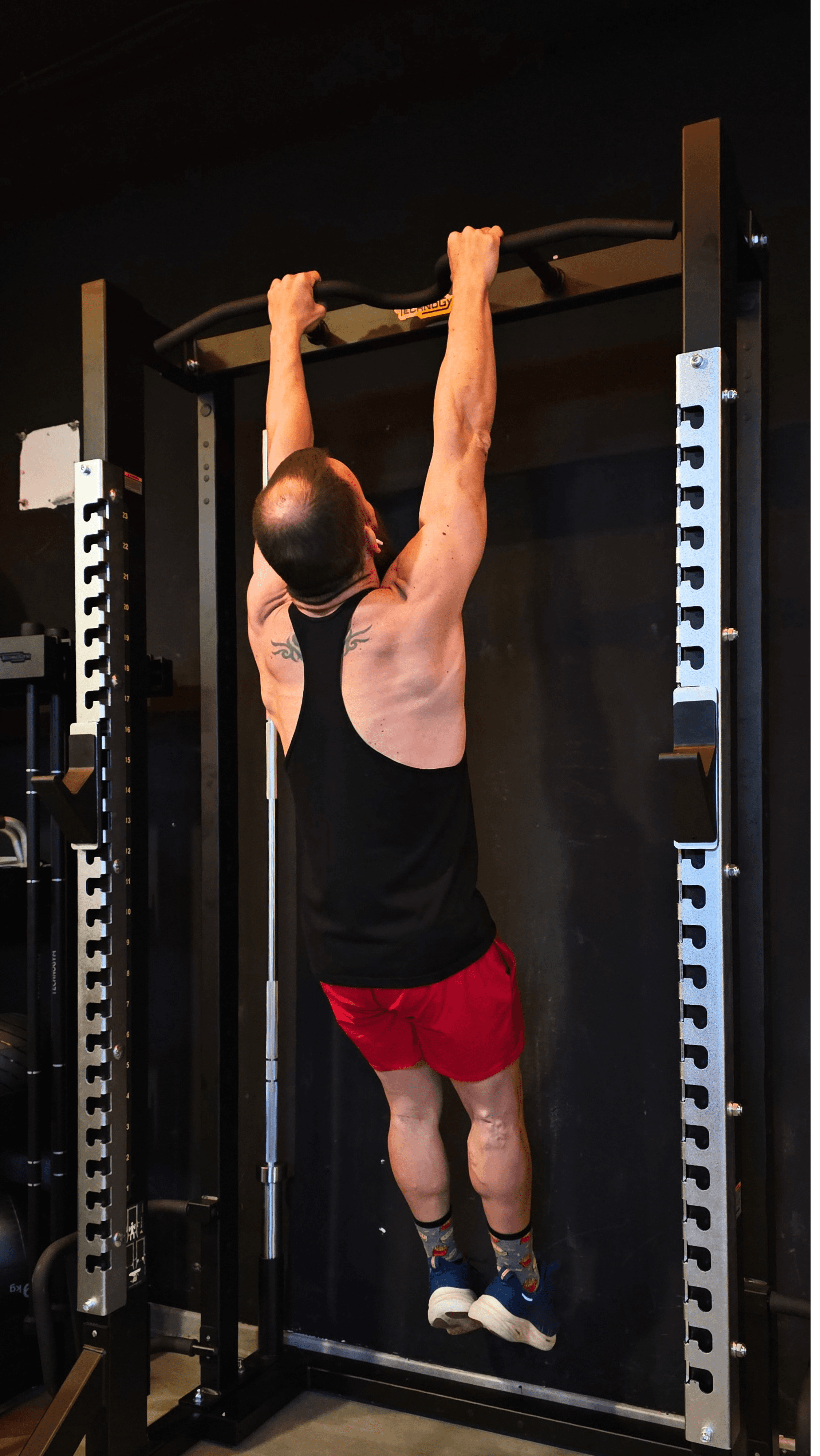 Hombre entrenando dominadas explosivas en gimnasio en Alicante