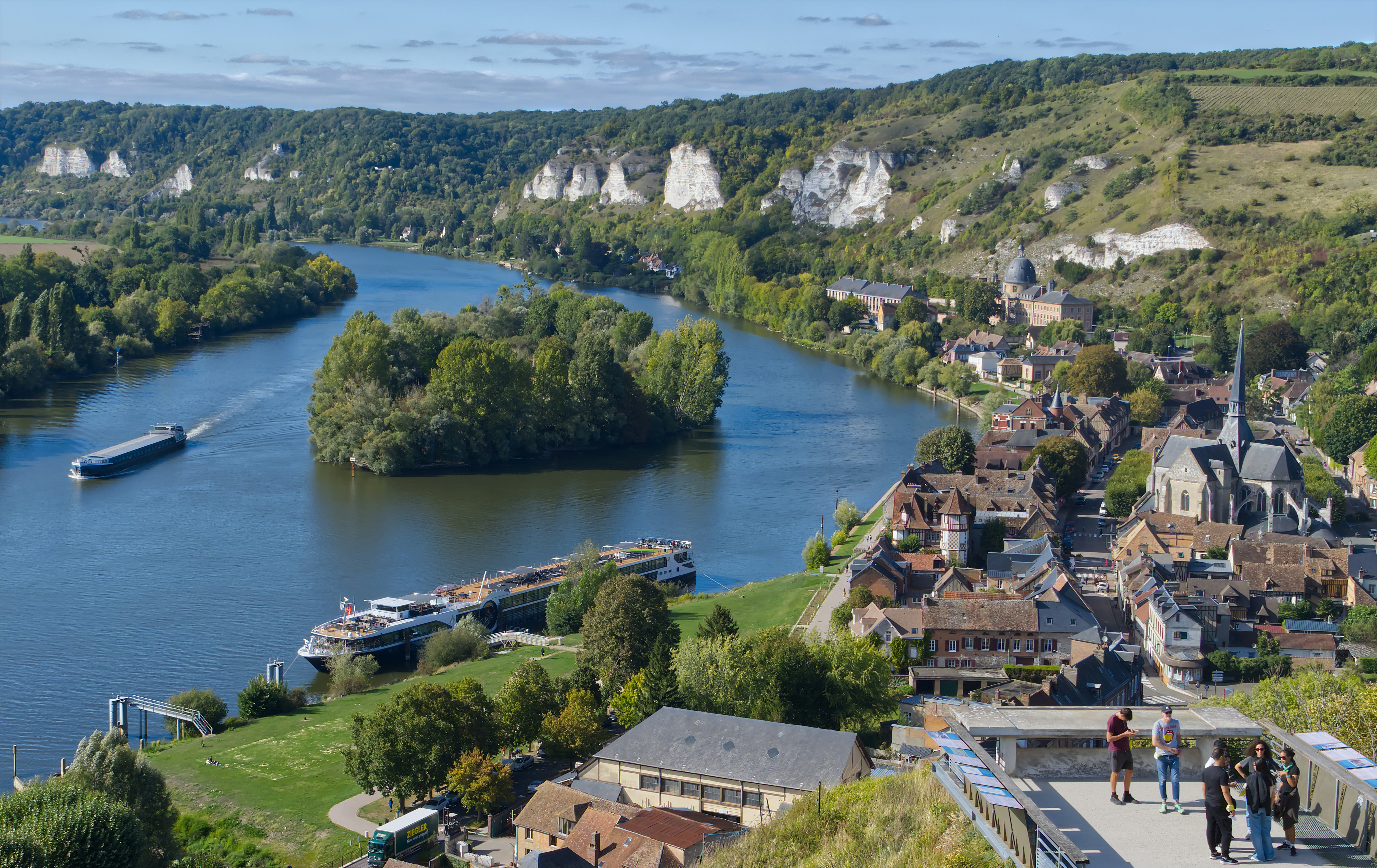 River bends through a scenic town with green hills.