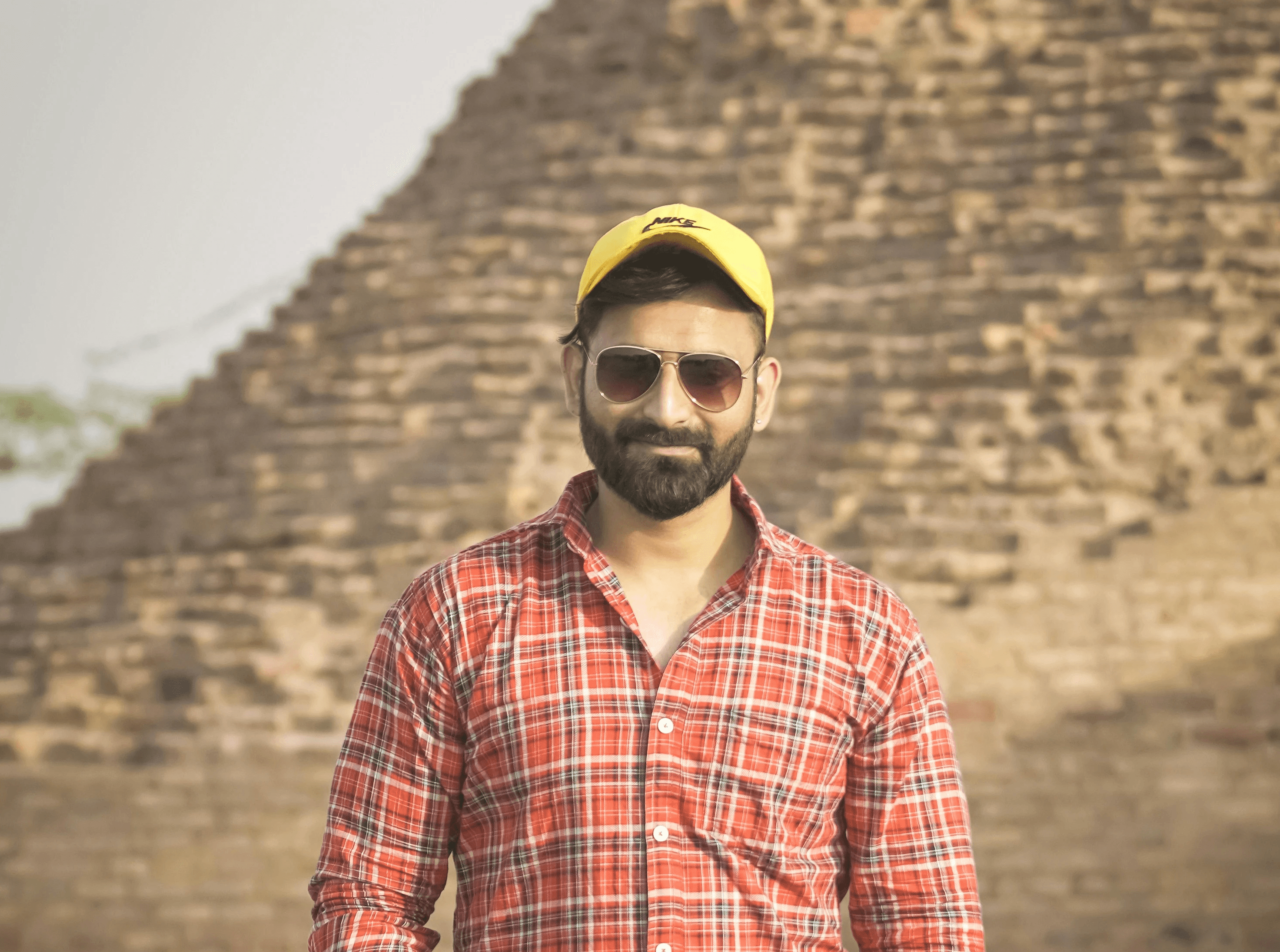 man in red and white plaid dress shirt and blue denim jeans standing on road during