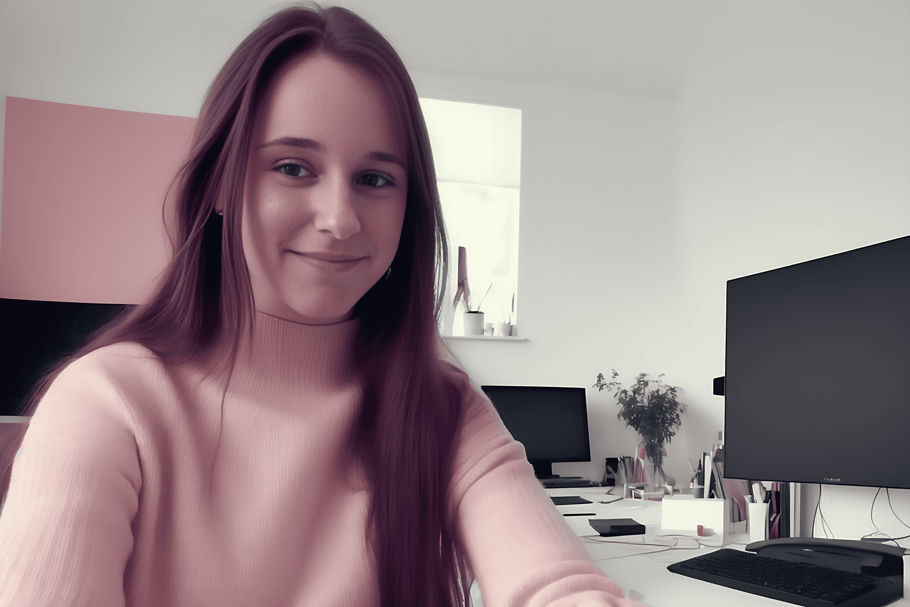 Annika wearing a knitted sweater in front of a work desk