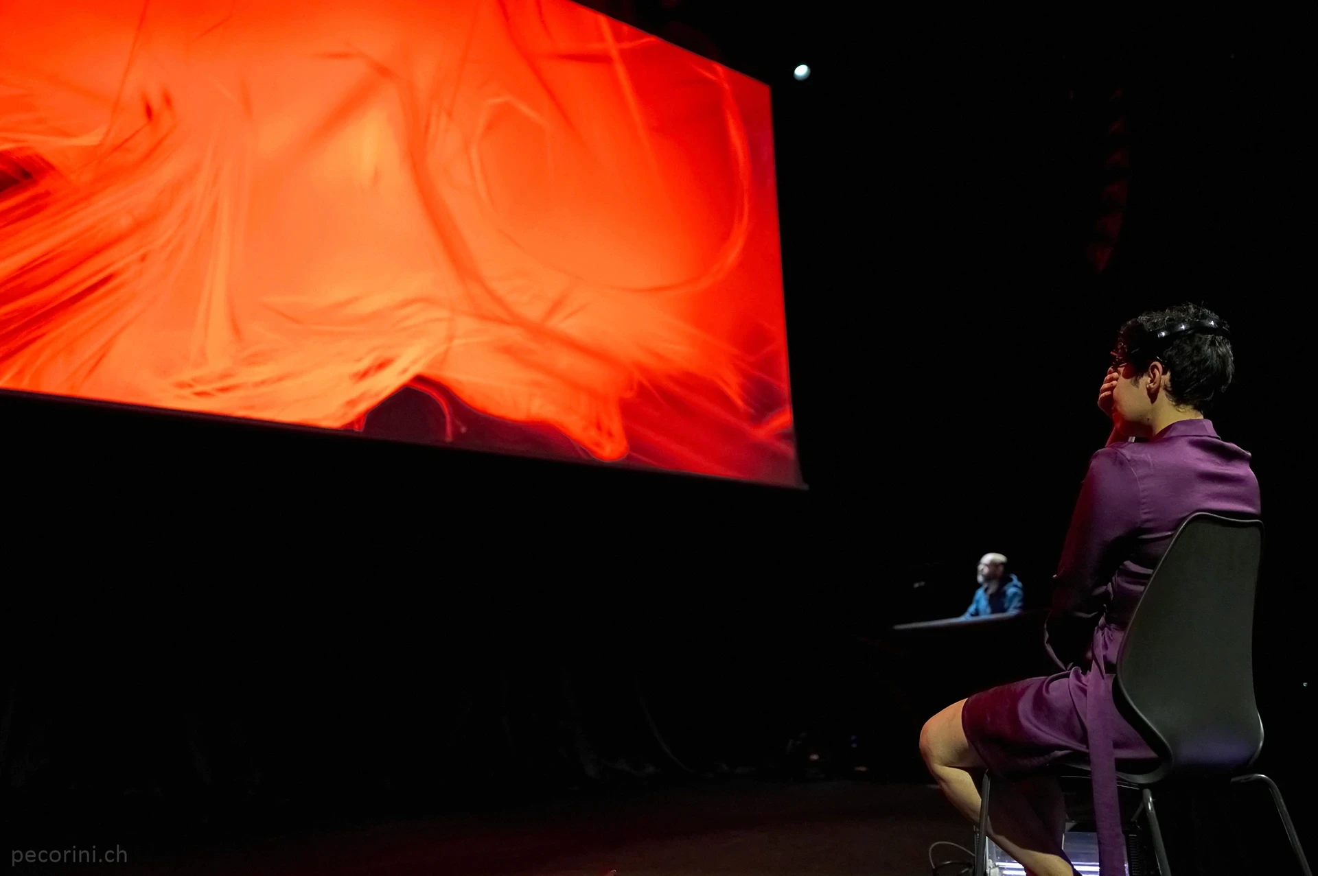 Person in purple watching large screen display