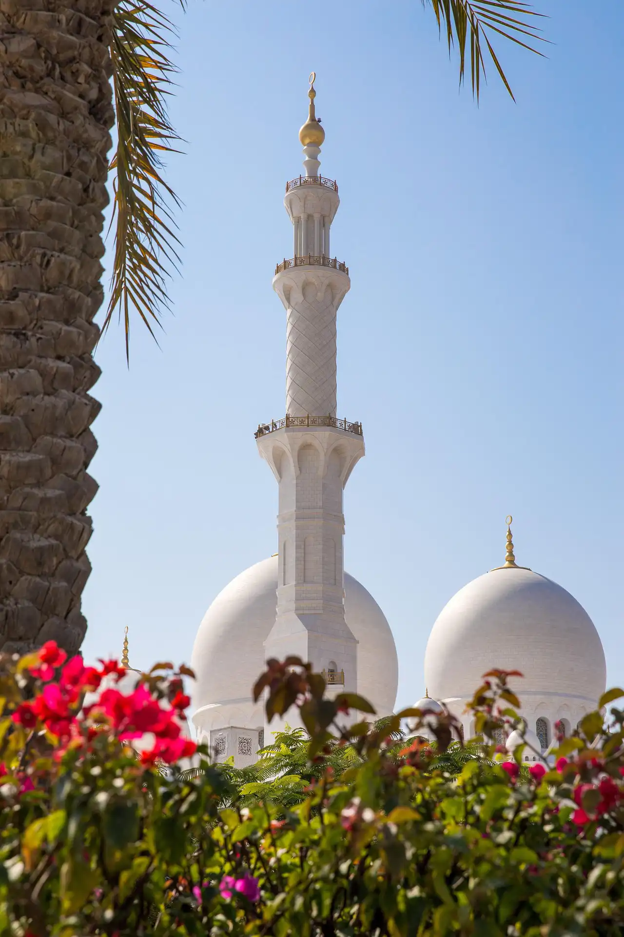 Mosque in Dubai with domes and minaret under clear sky