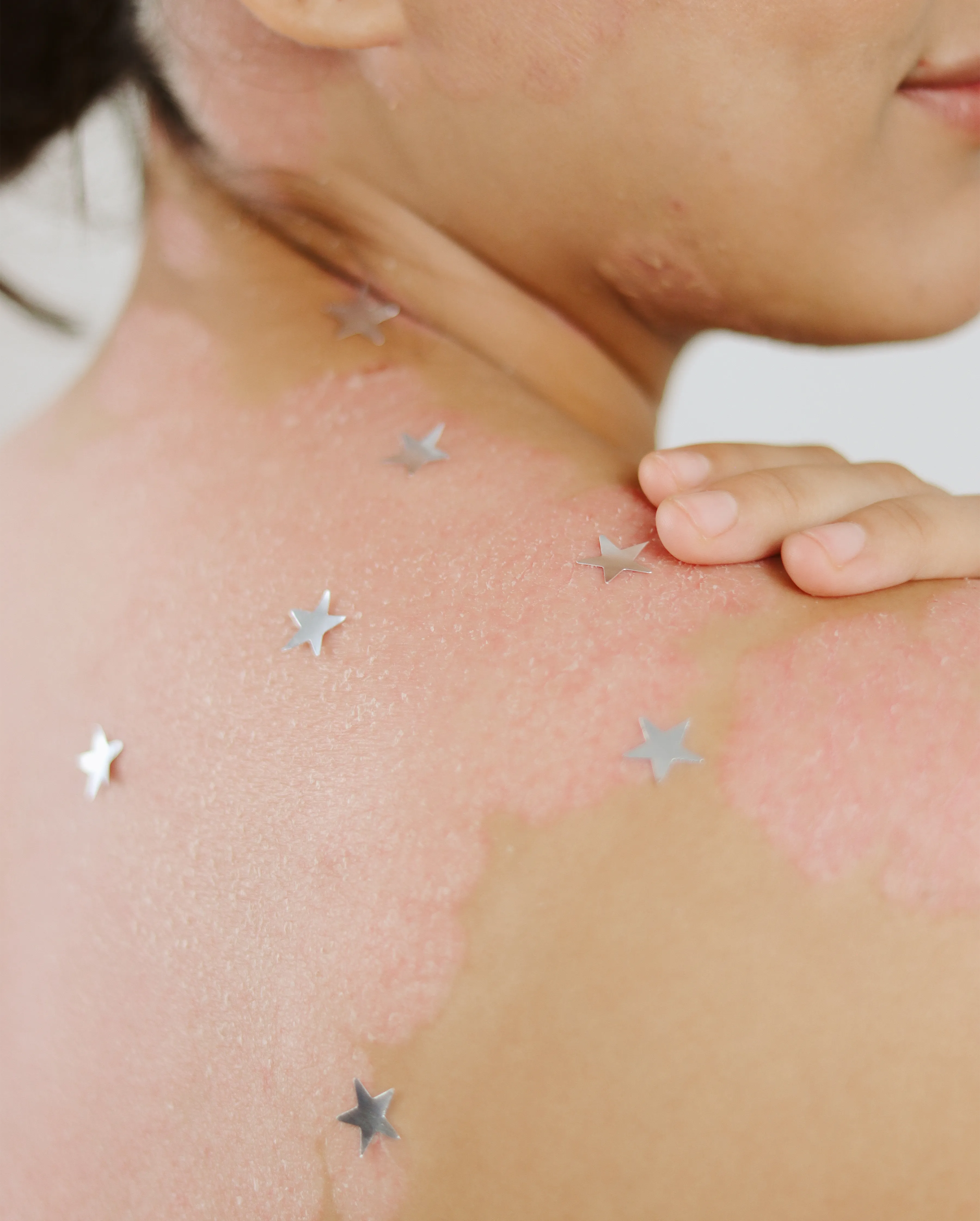 Detalle de espalda con estrellas plateadas sobre la piel