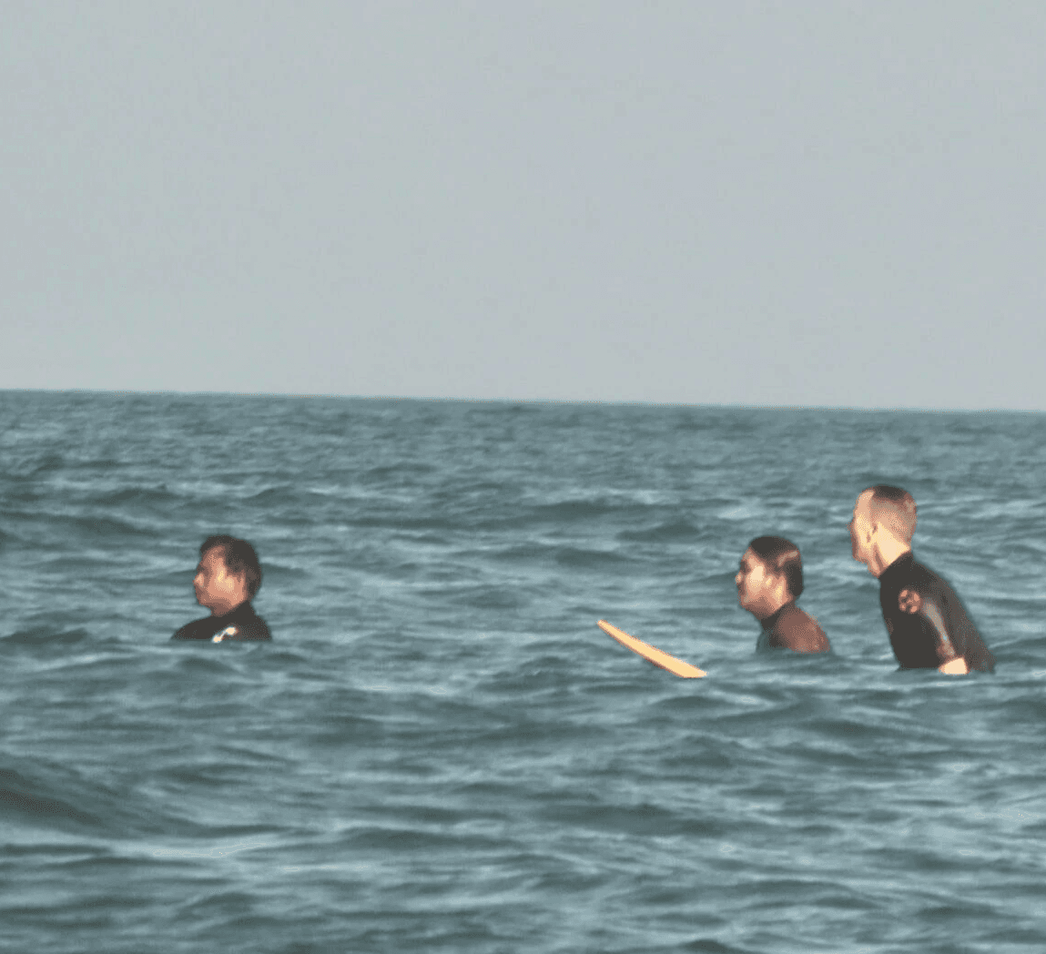 Group of men standing with Sufboard