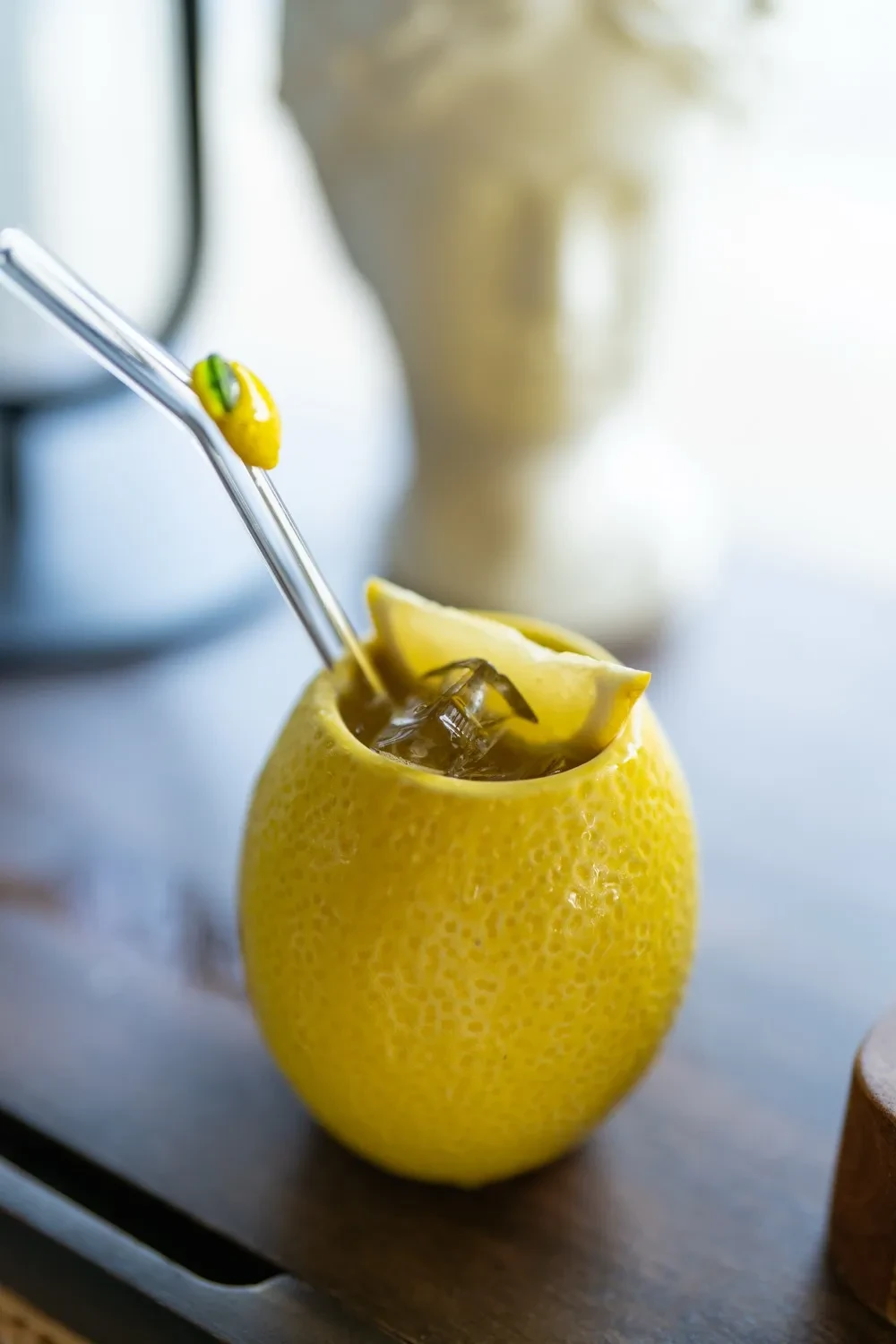 A phone, pad, and pen sit on a wooden desk.