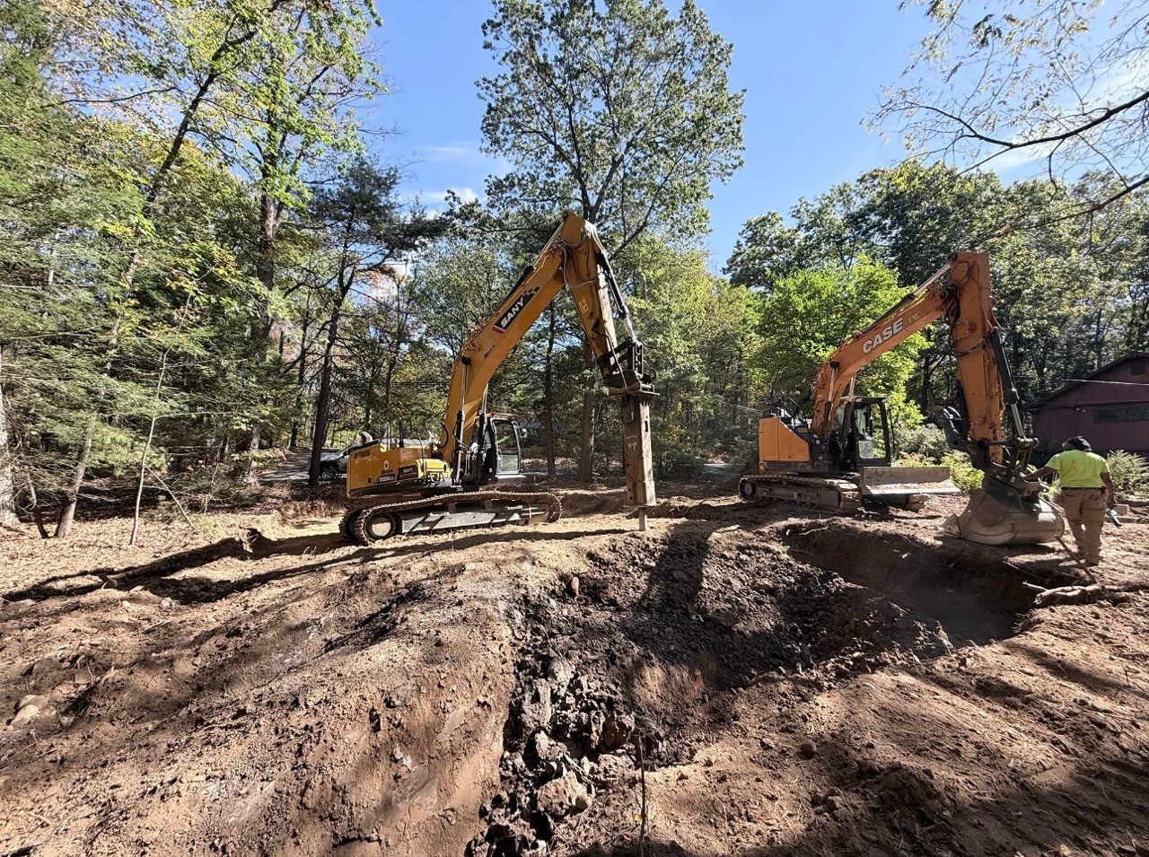 Two A&M excavators digging at golden hour